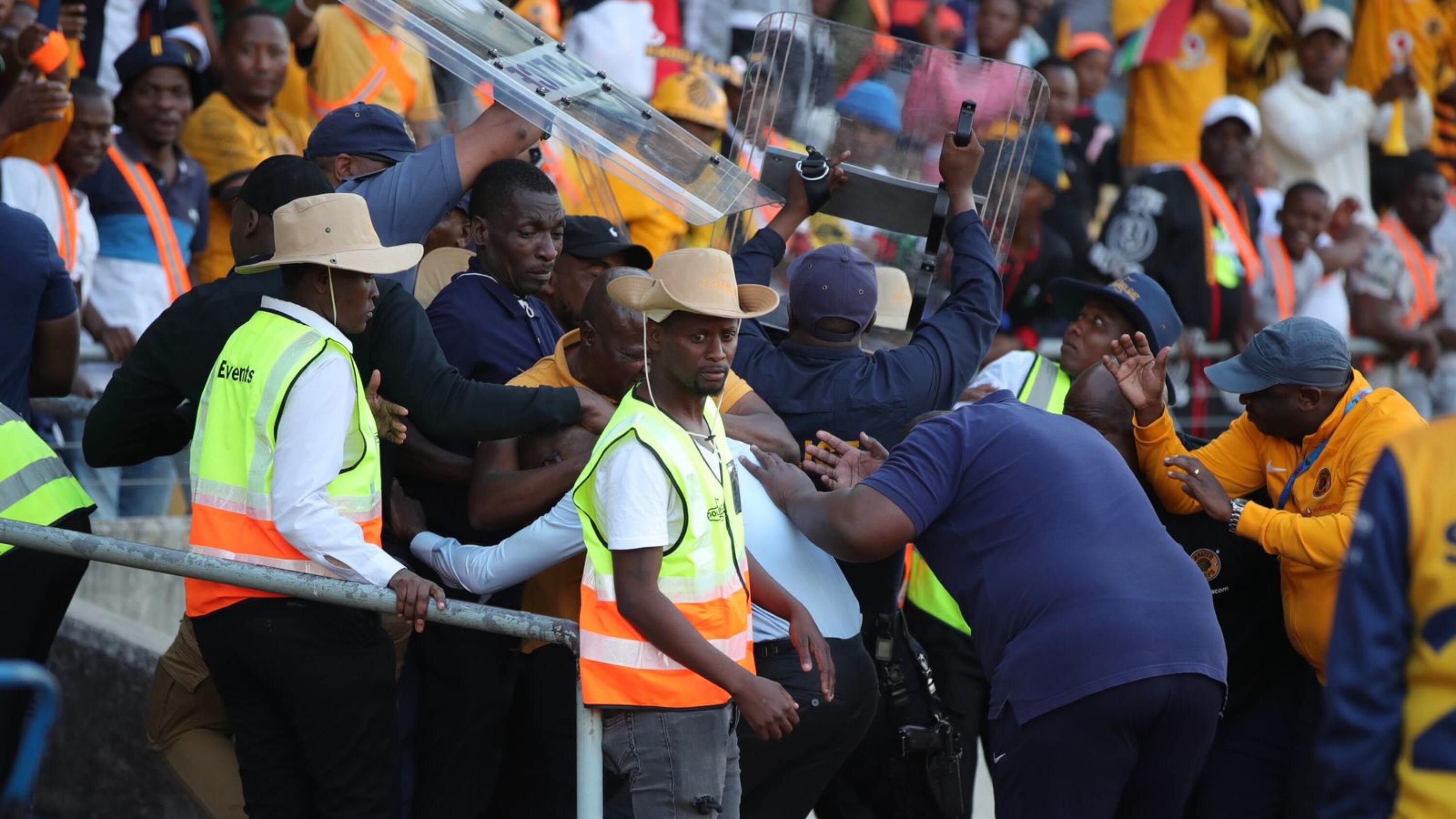 Kaizer Chiefs head coach Arthur Zwane is escorted by police after being attacked by the club’s fans after their DStv Premiership match against Supersport United at Royal Bafokeng Stadium in Rustenburg on Saturday
