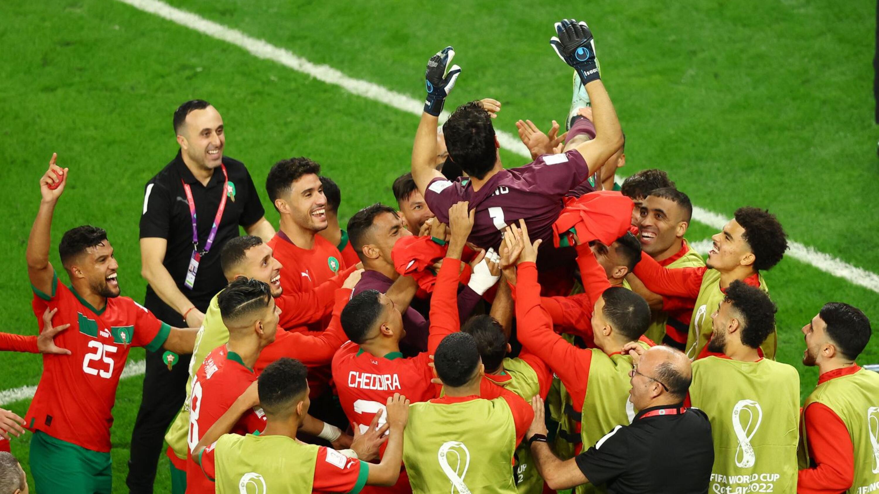 Morocco players throw Yassine Bounou in the air as they celebrate qualifying for the quarter finals after beating Spain at Education City Stadium on Tuesday