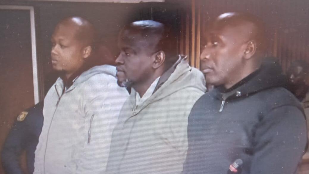 The suspects standing in the dock before the magistrate. 