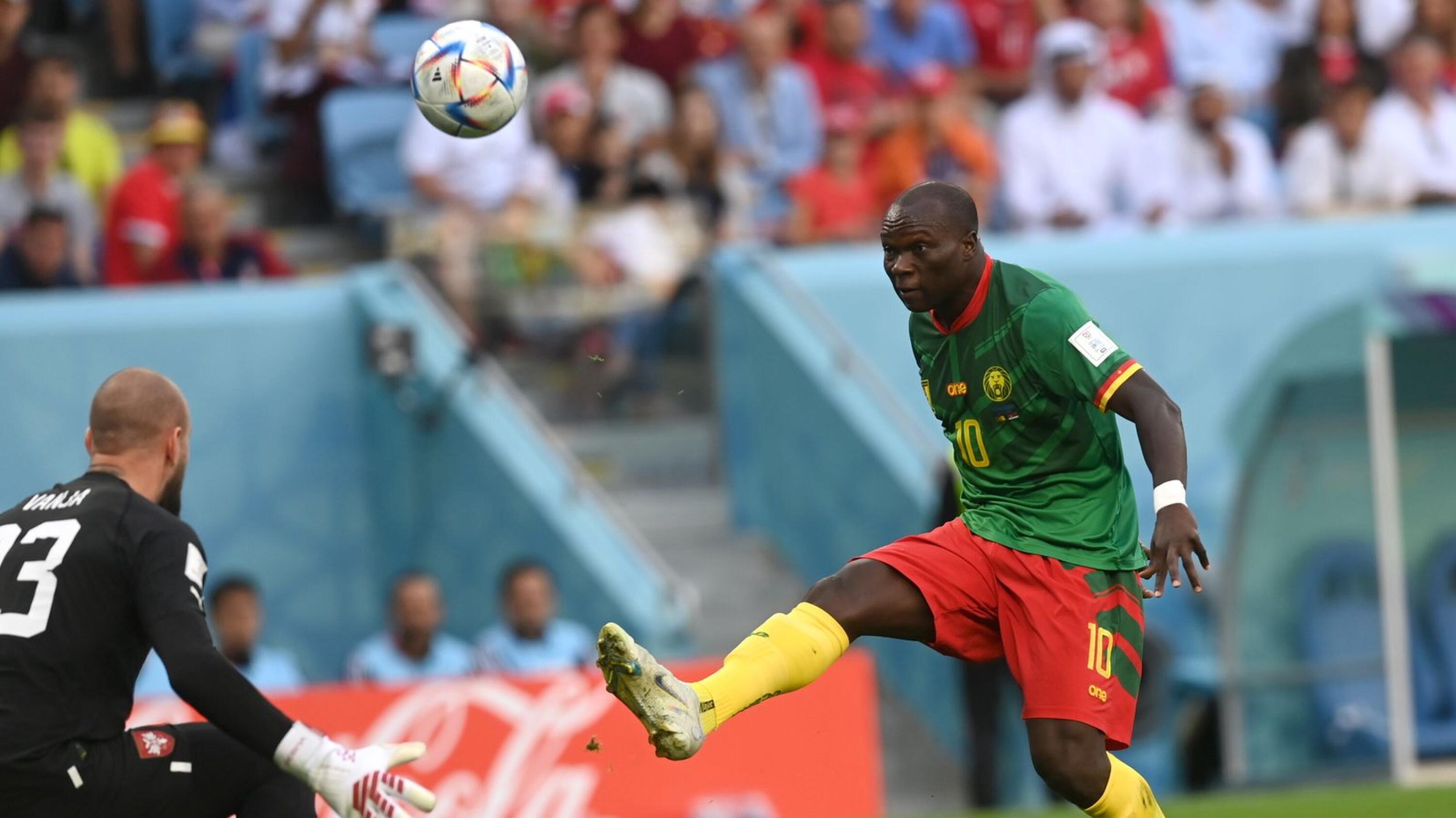 a Cameroon soccer players lobs a shot over the opposition goalkeeper