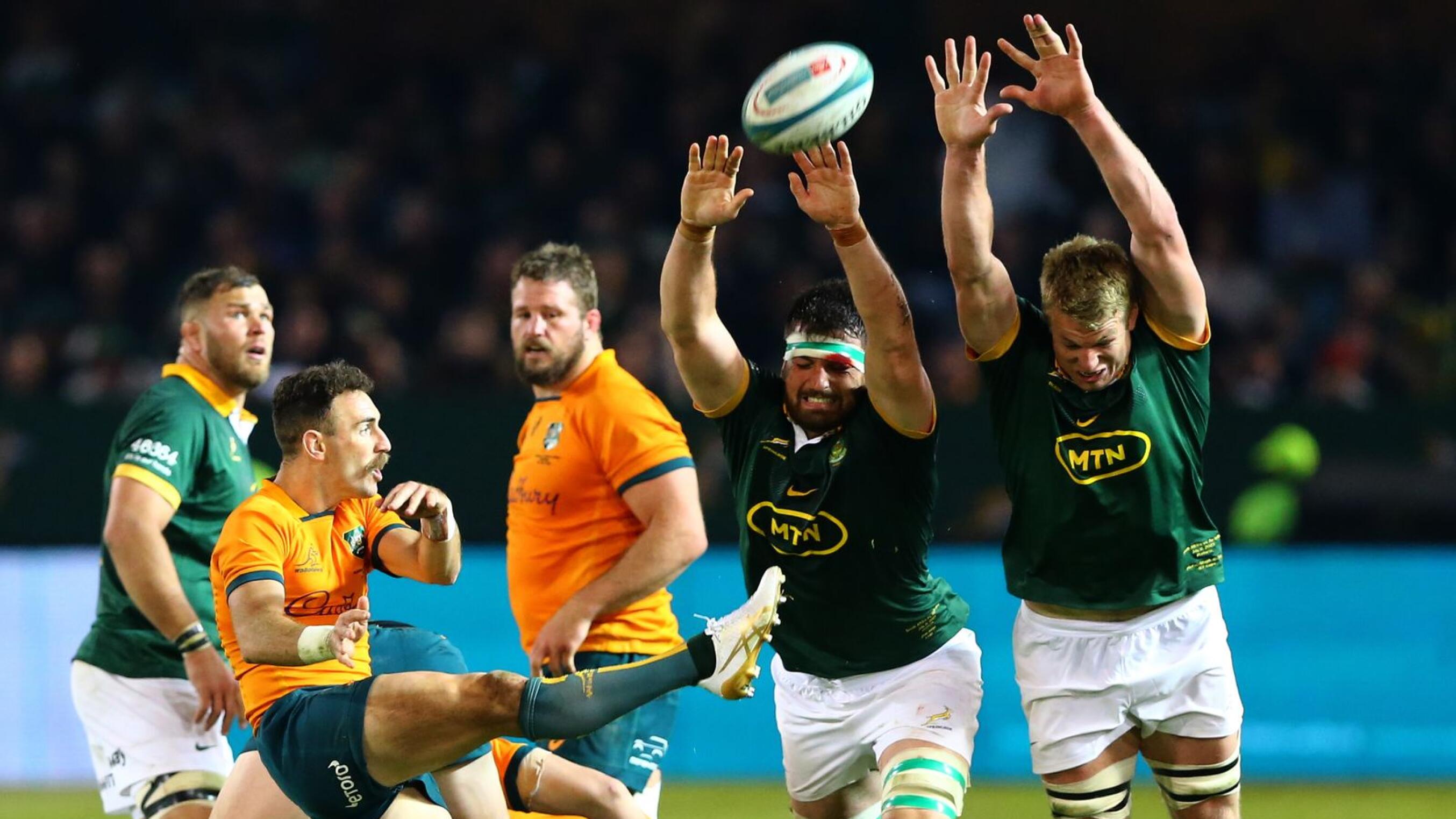 Australia's Nic White (L) kicks the ball from the base of the scrum while South Africa's Jean Kleyn (2-R) and Pieter-Steph du Toit (R) try to stop the kick during the Rugby Championship.