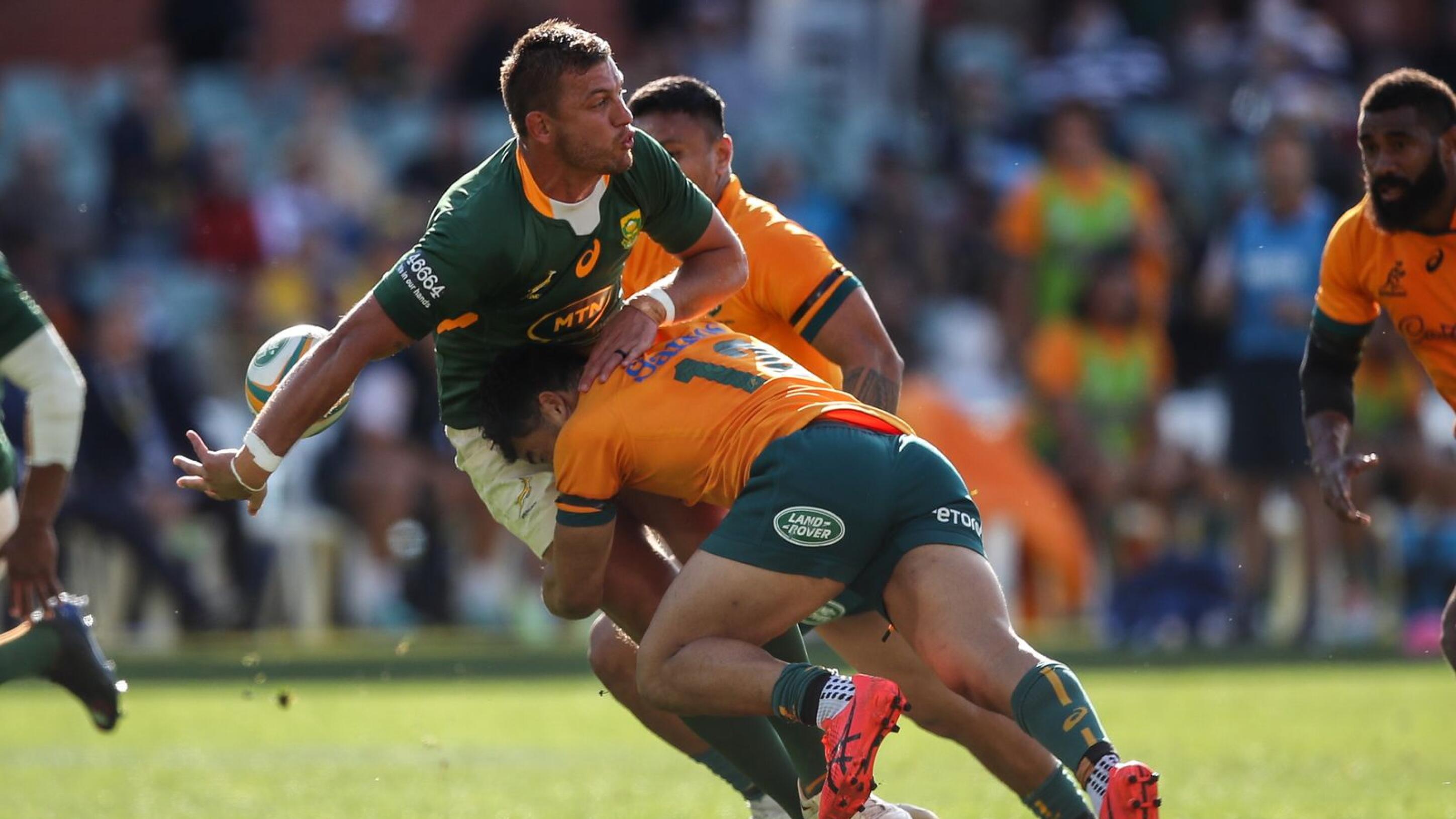 a springbok rugby player is tackled by an Australia rugby player
