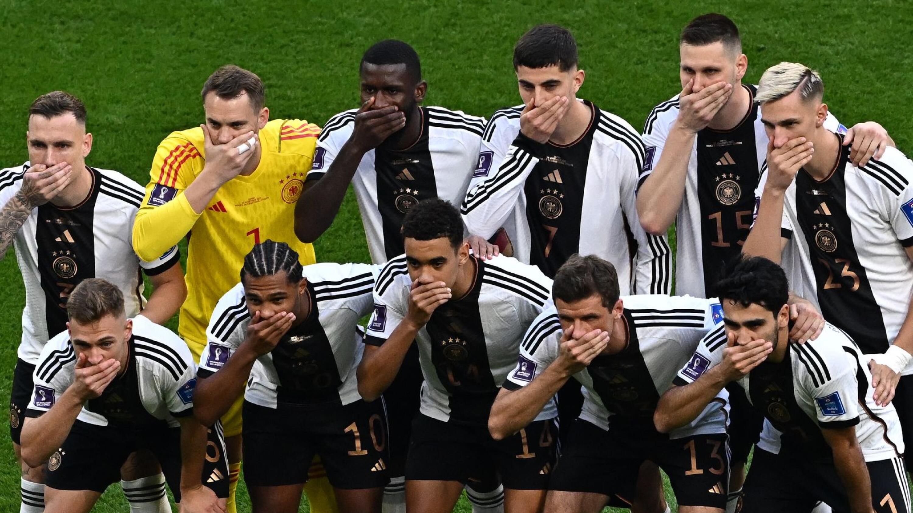Germany's players cover their mouths as they pose for a group picture ahead of their Qatar 2022 World Cup Group E football match against Japan at the Khalifa International Stadium in Doha on Wednesday