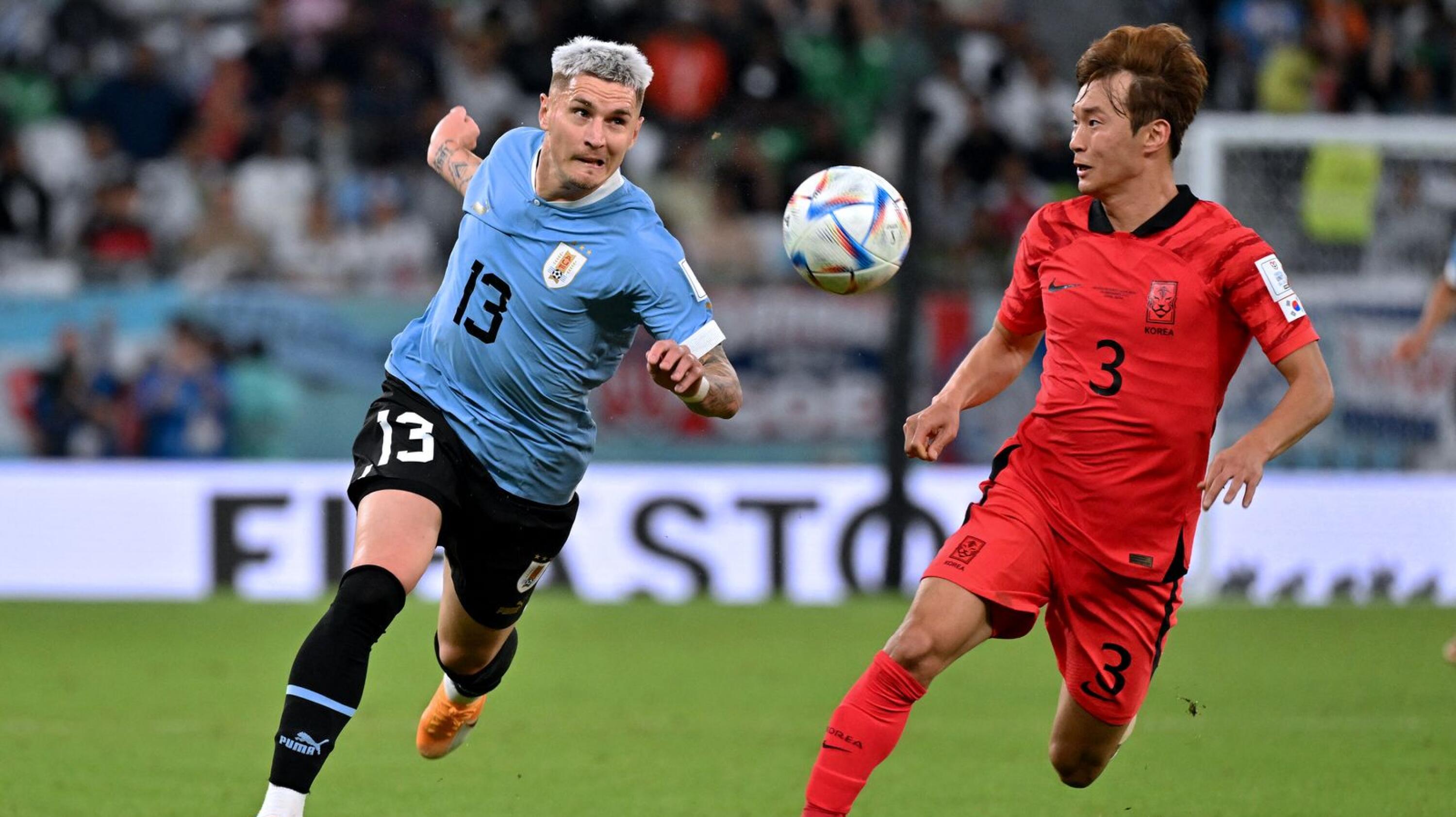 Uruguay's Guillermo Varela (left) and South Korea's Kim Jin-su battle for the ball during their World Cup Group H football match at the Education City Stadium in Al-Rayyan on Thursday