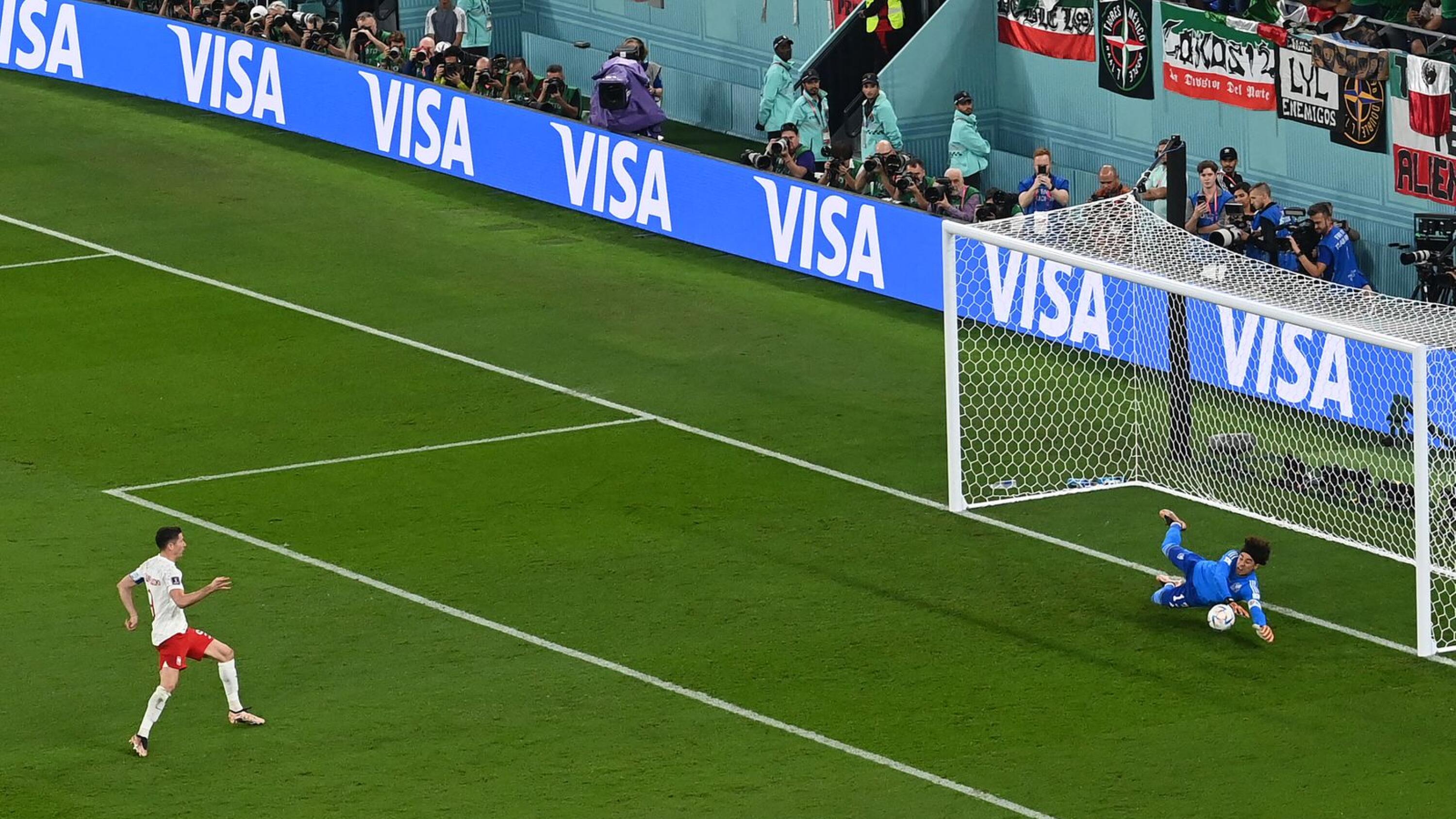 Mexico's Guillermo Ochoa saves a penalty kick by Poland's Robert Lewandowski during their Qatar 2022 World Cup Group C football match at Stadium 974 in Doha on Tuesday