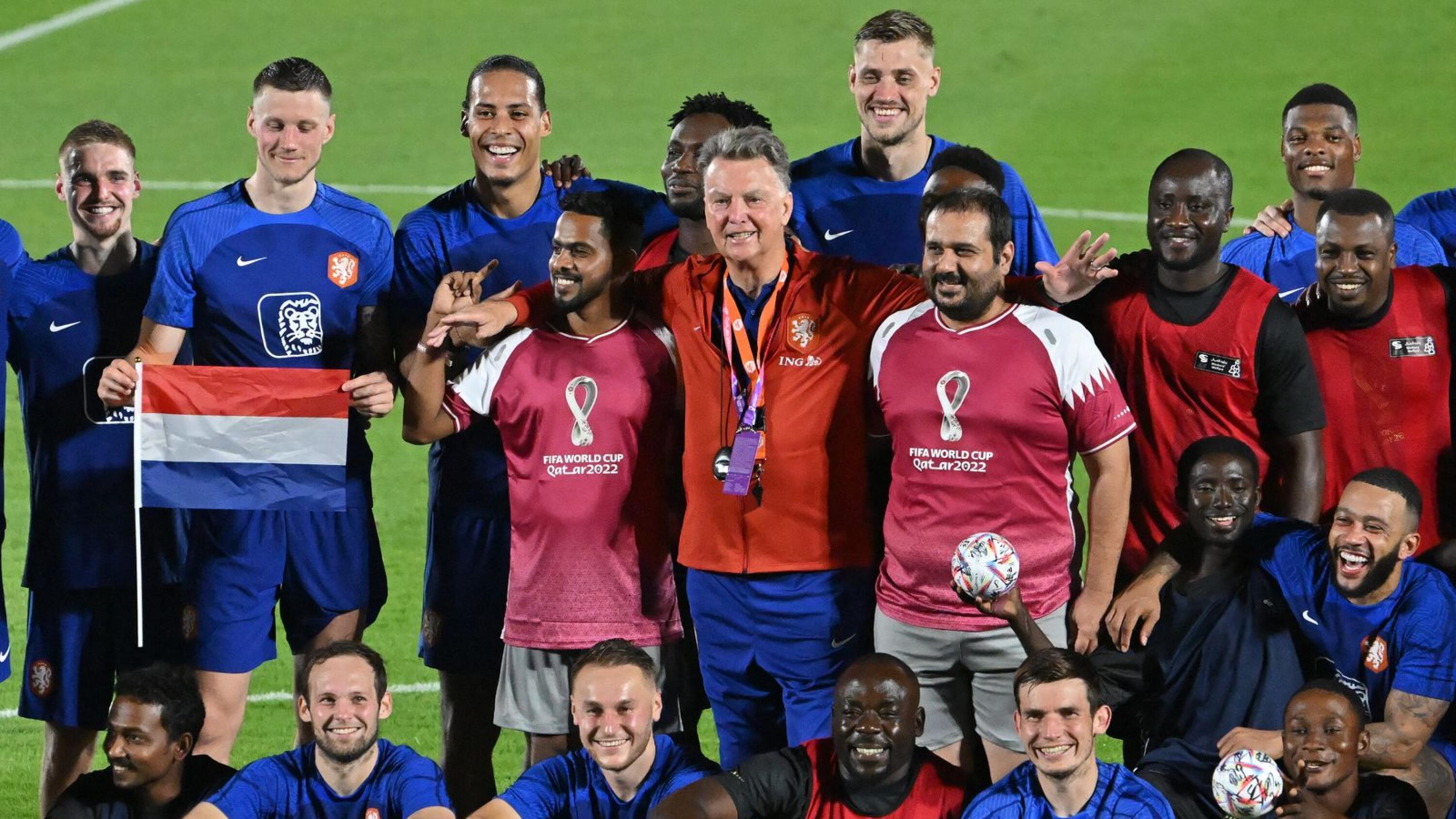 The Netherlands' national football team players pose for pictures with a football team of the delegation of workers during a training session at Qatar University training on Thursday