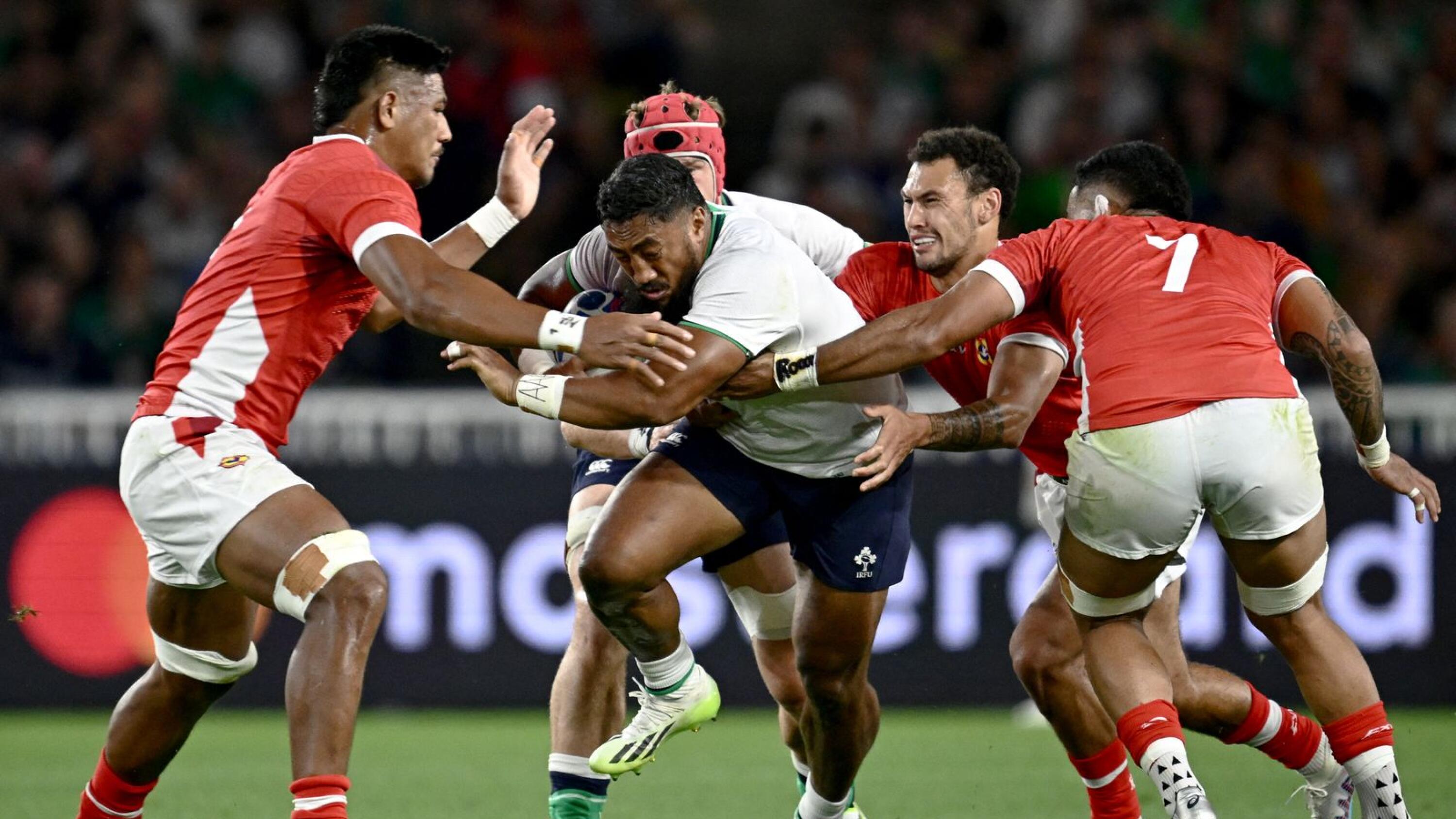 Ireland's centre Bundee Aki runs with the ball surrounded by Tonga's players during their Rugby World Cup Pool B match at the Stade de la Beaujoire in Nantes on Saturday
