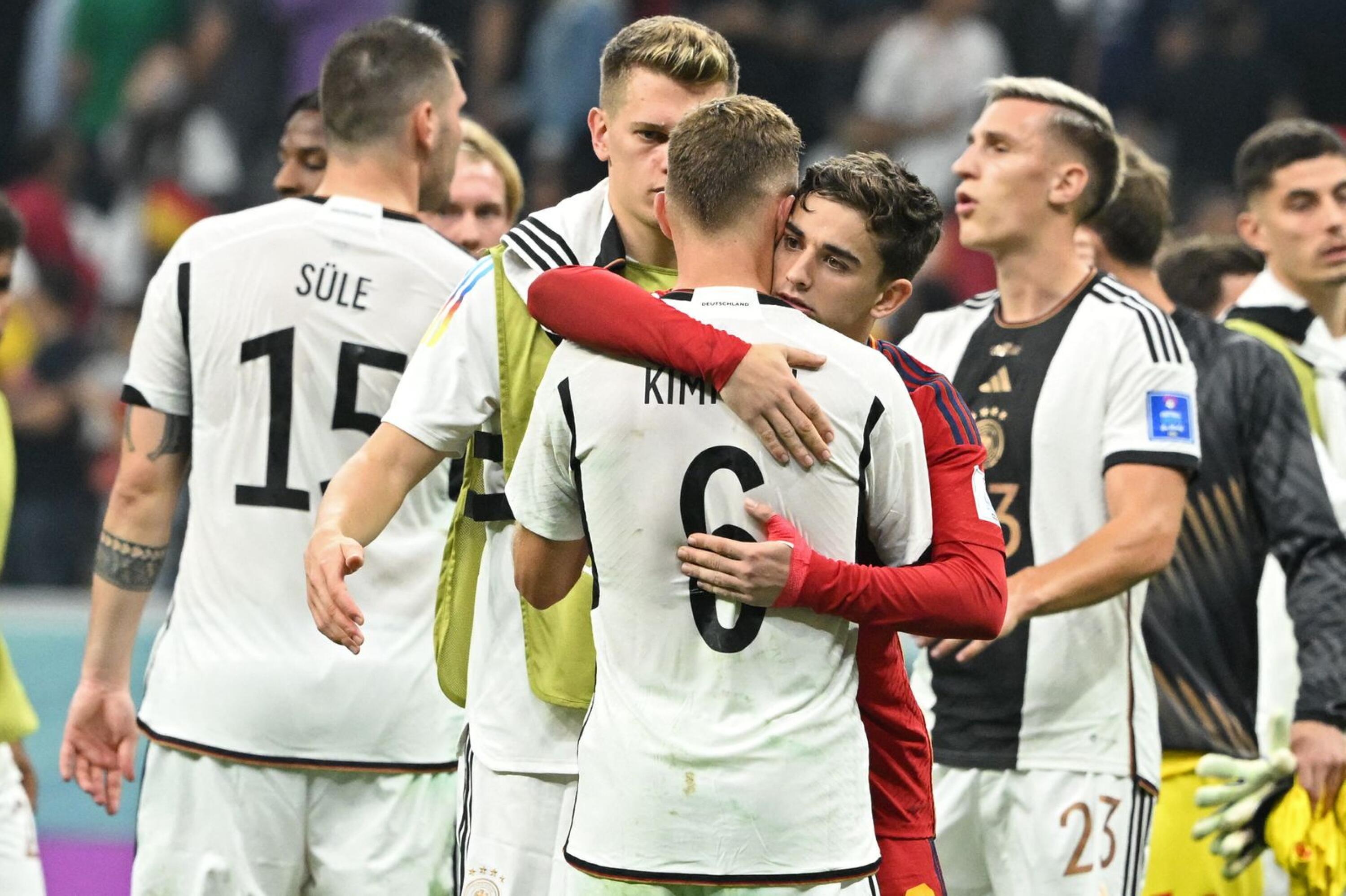 Germany's Joshua Kimmich hugs Spain's Gavi at the end of their Qatar 2022 World Cup Group E football match at the Al-Bayt Stadium in Al Khor, north of Doha on Sunday