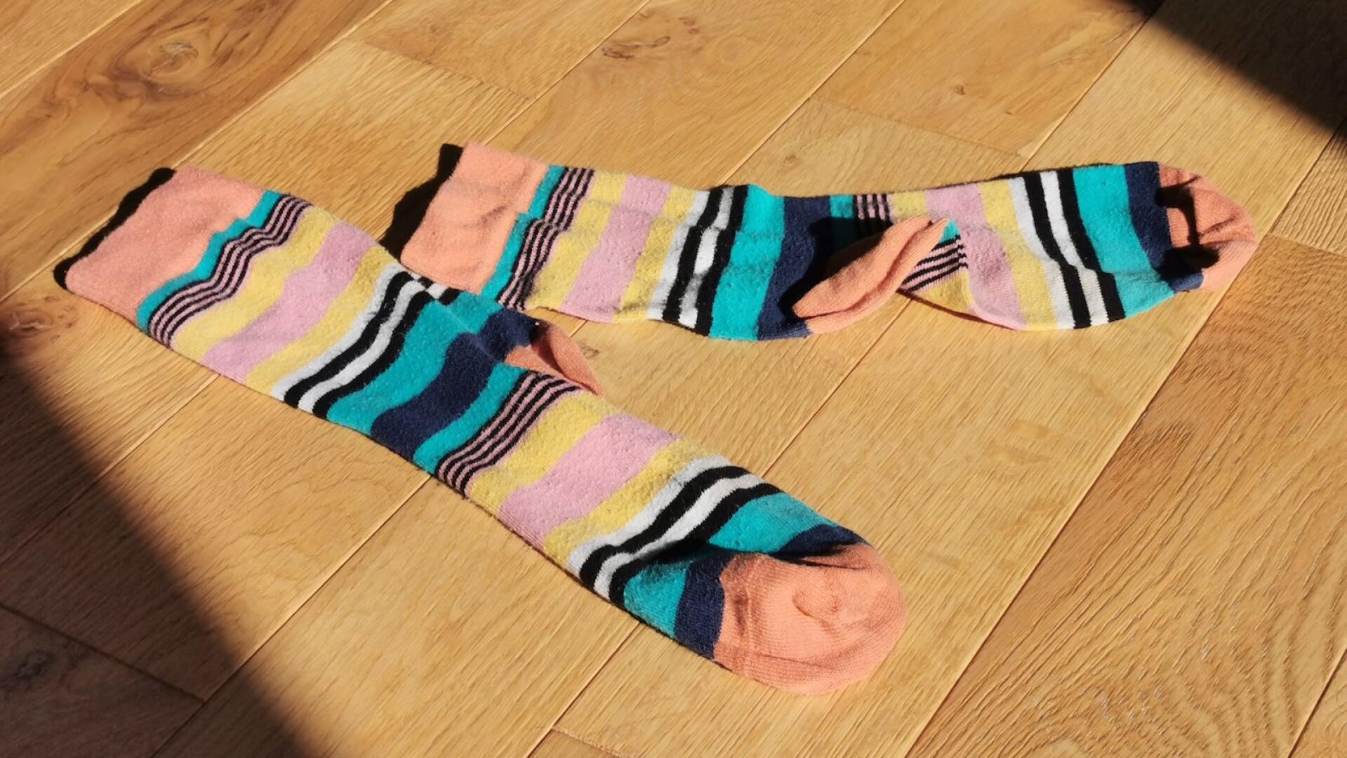 Pair of striped socks on the floor. 