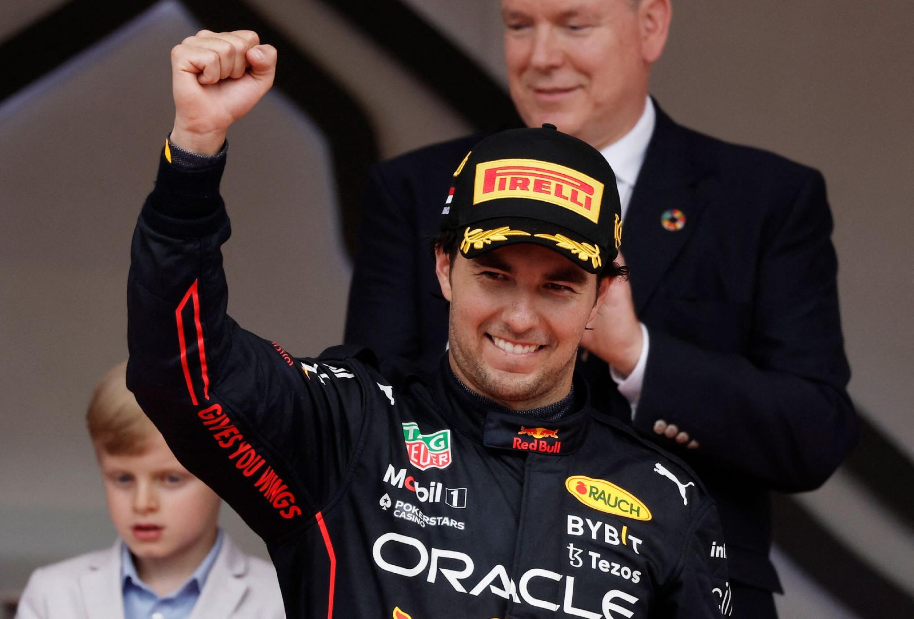 Red Bull's Sergio Perez celebrates on the podium after winning the race as Prince Albert II of Monaco applauds