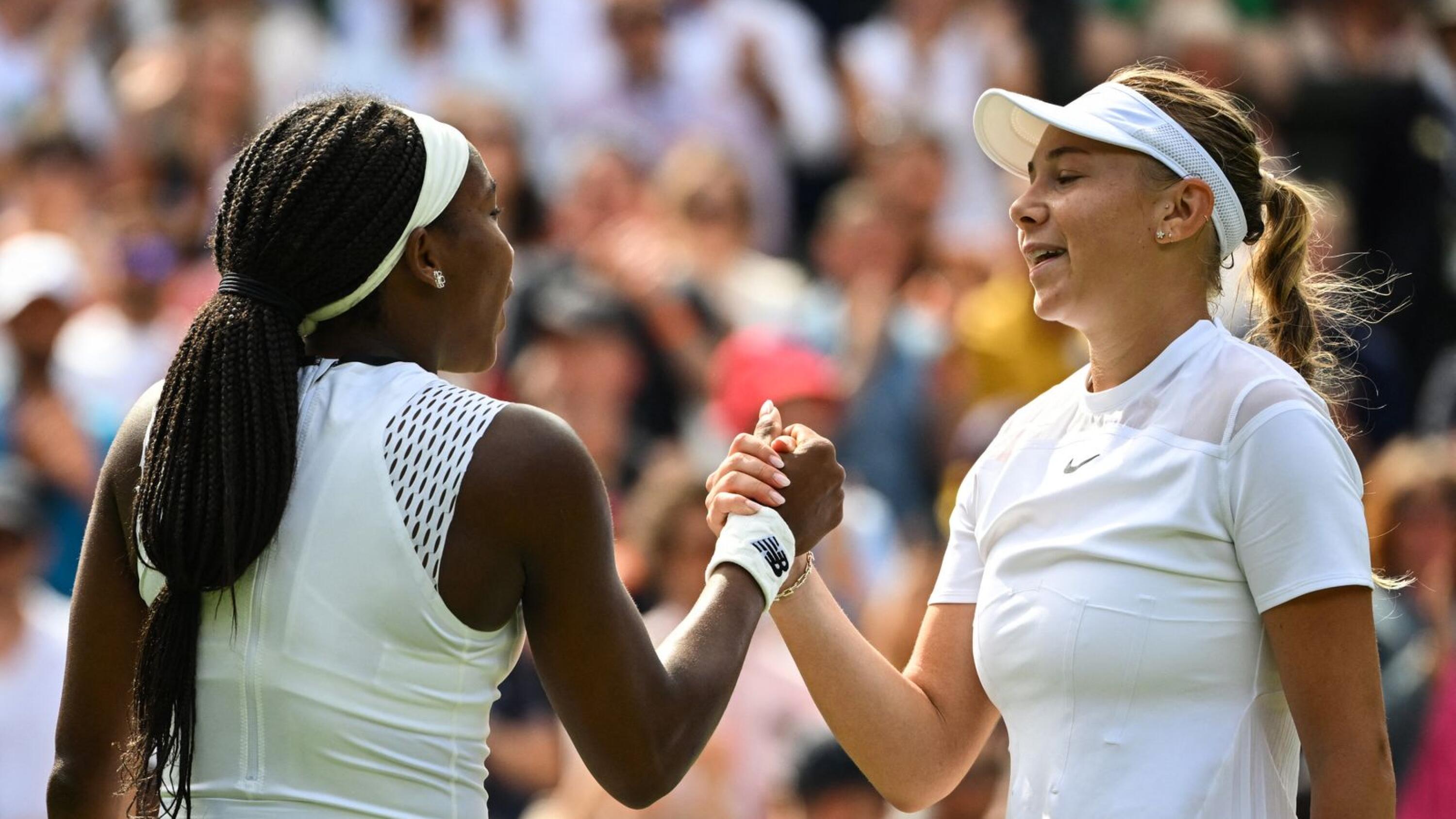 Amanda Anisimova (R) shakes hands with compatriot Coco Gauff after winning at the end of their women's singles tennis match on the sixth day of the 2022 Wimbledon Championships at The All England Tennis Club in Wimbledon, southwest London, on Saturday