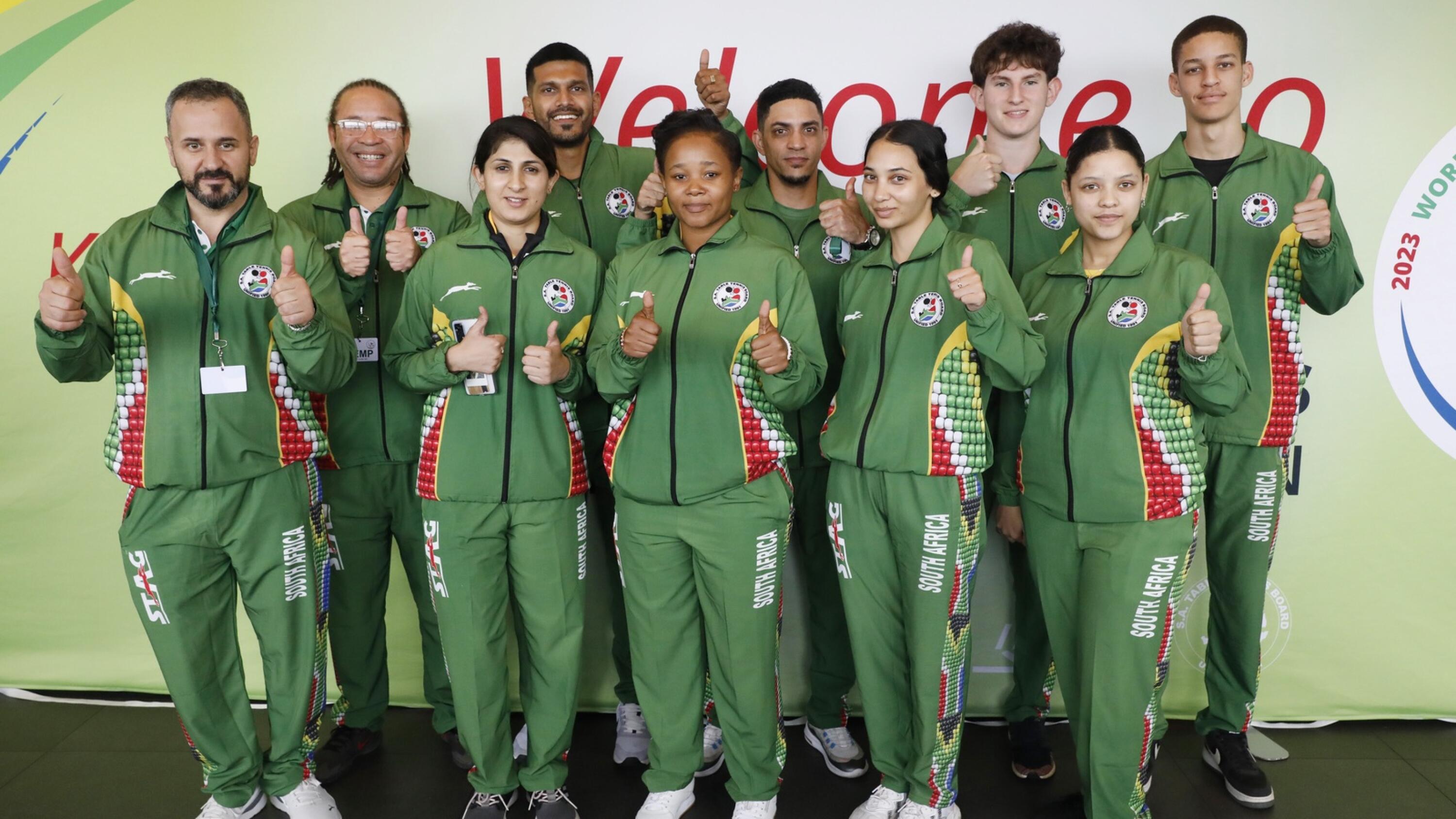 Table tennis team in green South African tracksuits give a thumbs-up sign
