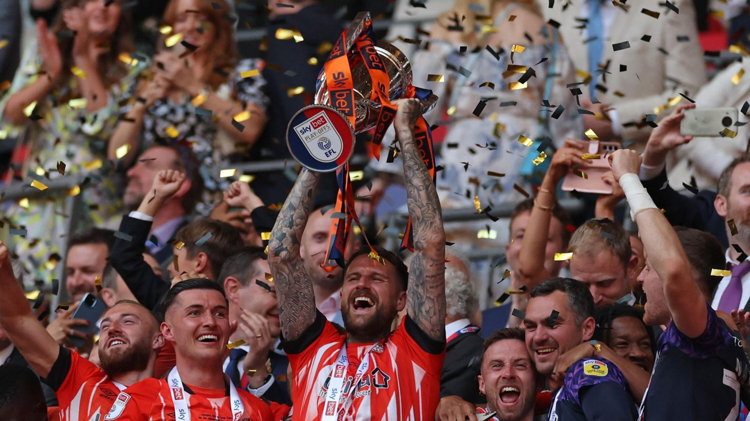 Luton Town’s Sonny Brady lifts up the Championship trophy.