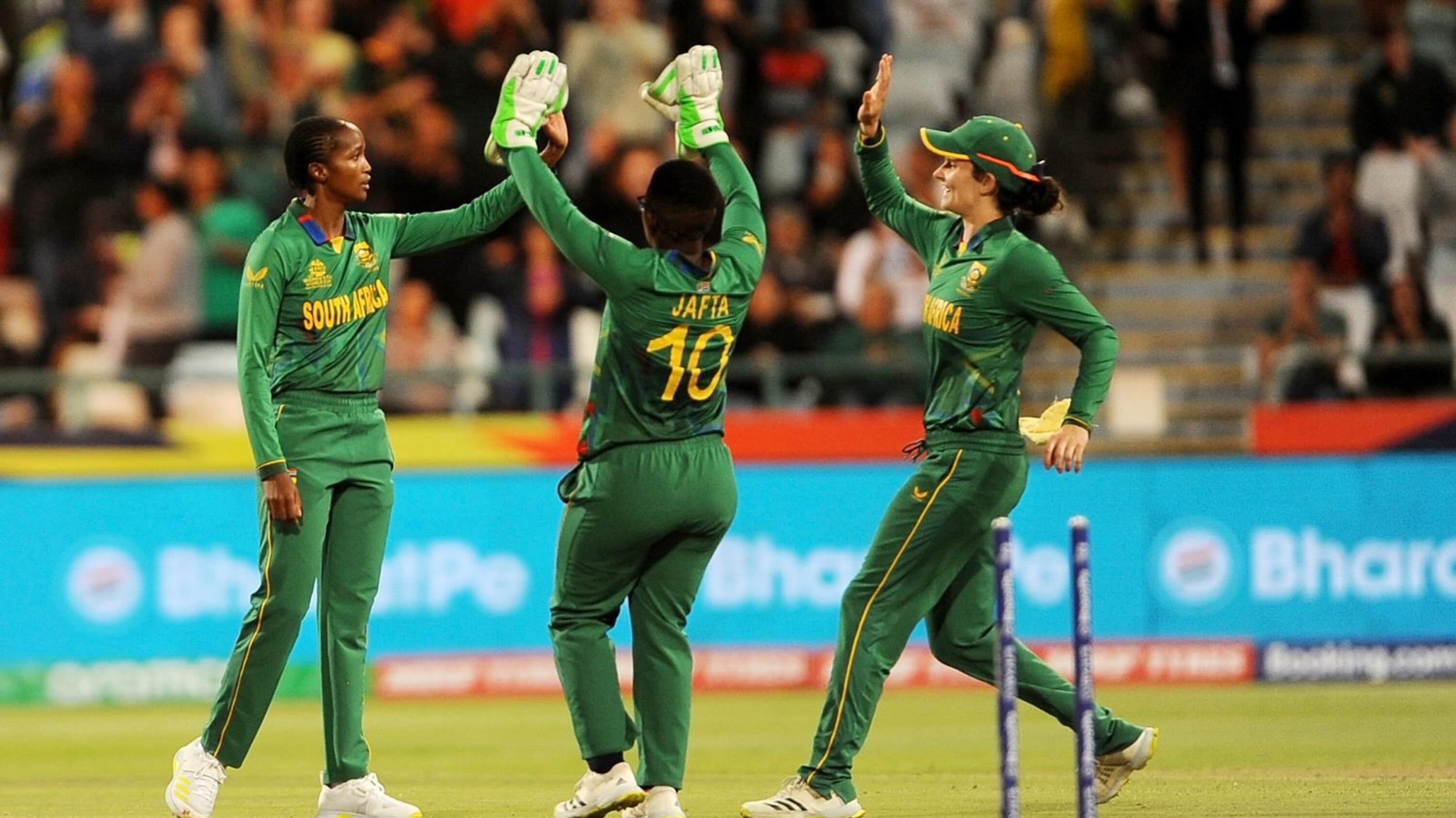 Ayabonga Khaka (left) of South Africa  celebrates with teammates Sinalo Jafta (centre) and Laura Wolvaardt during their ICC T20 Women's World Cup match against Bangladesghat the Newlands cricket stadium