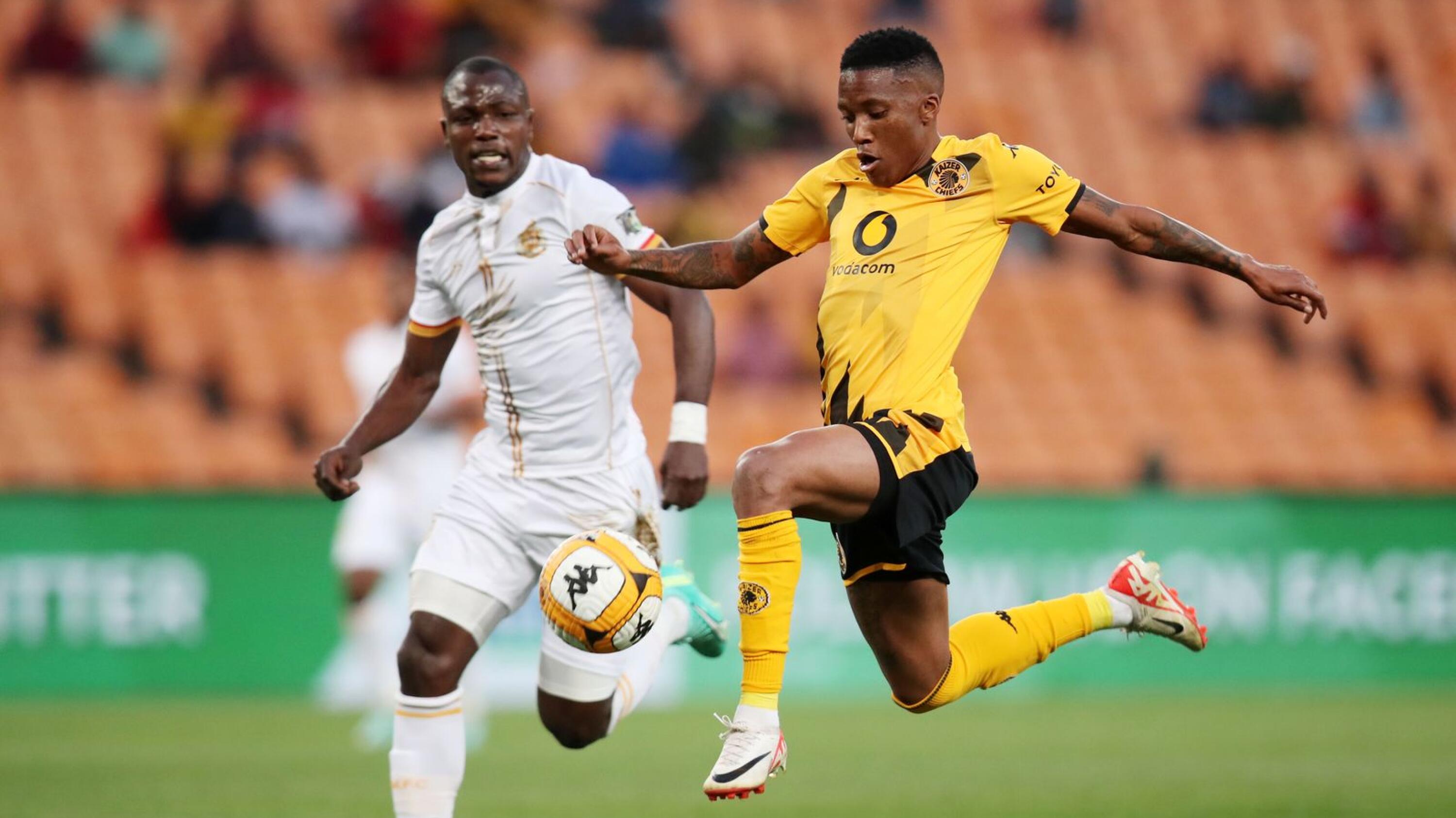 Pule Mmodi of Kaizer Chiefs is challenged by Levy Mashiane of Royal AM during their DStv Premiership match at FNB Stadium in Johannesburg on Saturday