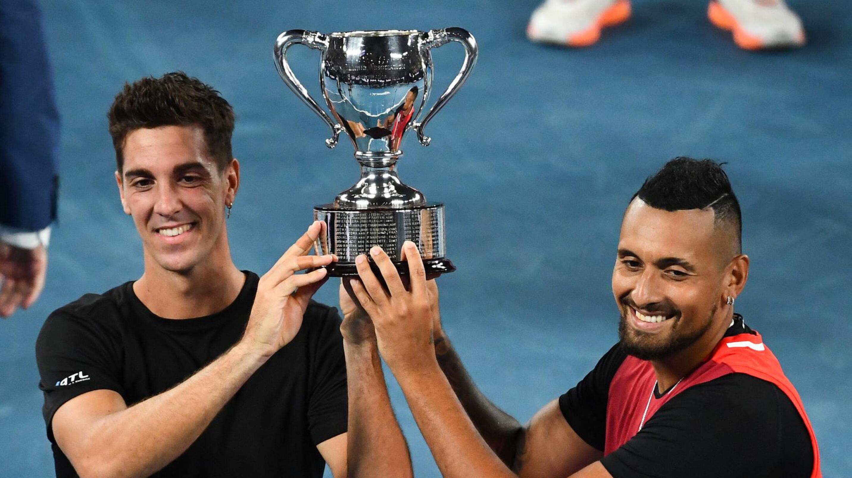 Australia's Thanasi Kokkinakis Nick Kyrgios pose with the trophy after winning against compatriots Matthew Ebden and Max Purcell during their men's doubles final match on day thirteen of the Australian Open tennis tournament in Melbourne on Saturday