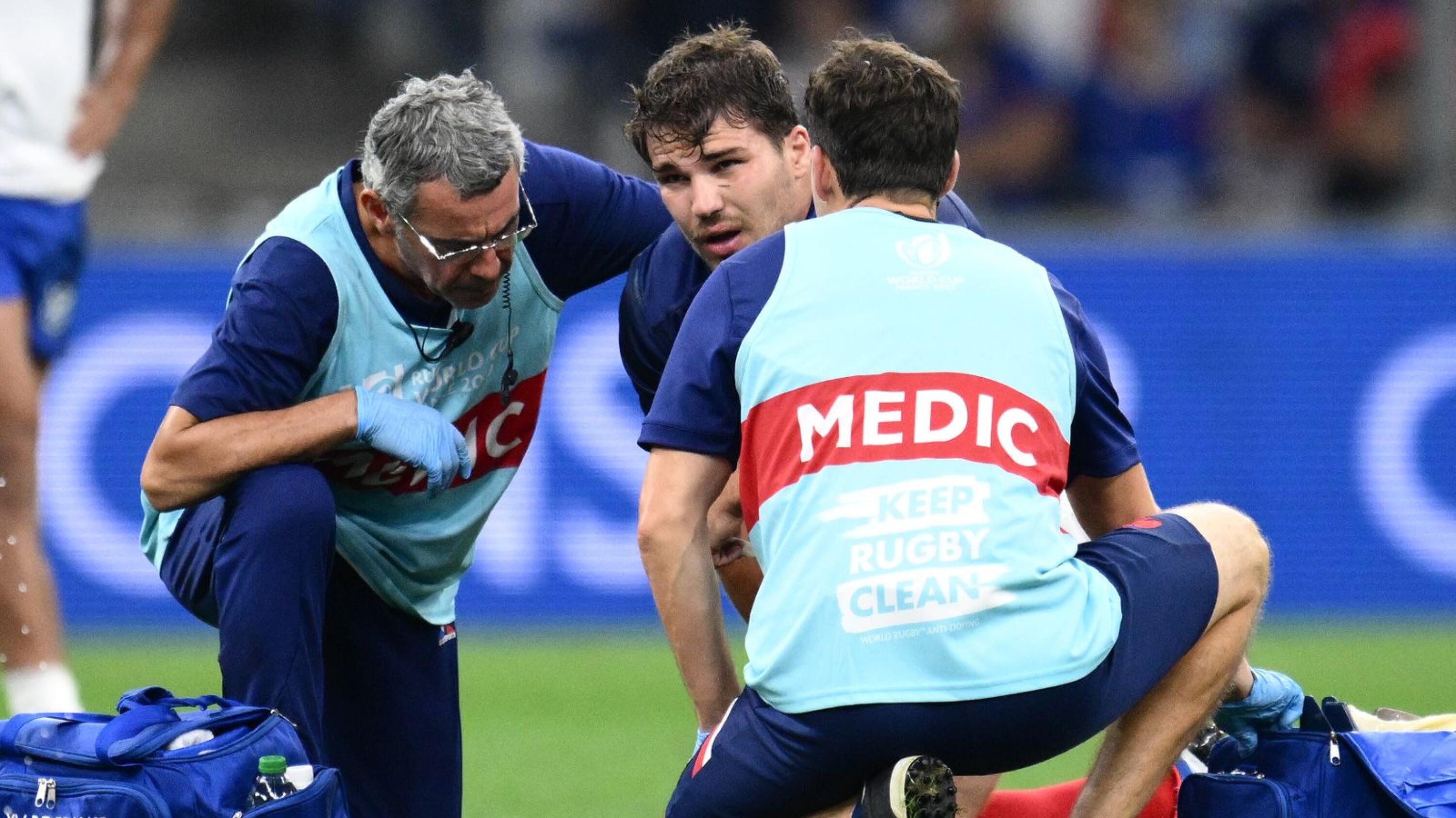 France's scrumhalf and captain Antoine Dupont (centre) receives medical attention during the France 2023 Rugby World Cup Pool A match between France and Namibia at the Stade de Velodrome in Marseille, southern France