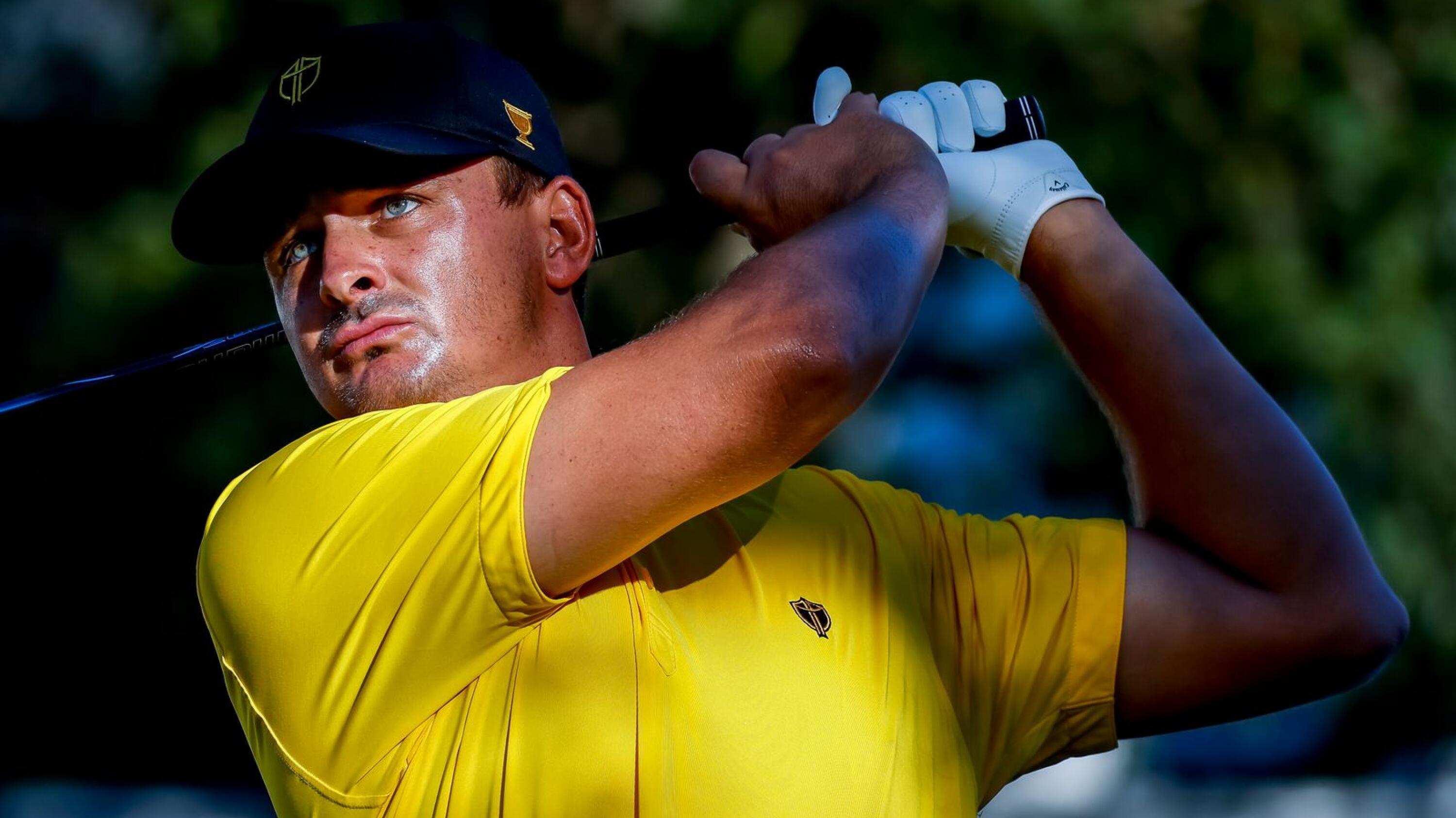 Photograph of golf player Christiaan Bezuidenhout, of South Africa, in a yellow shirt, swinging a golf club during the final practice round for the 2022 Presidents Cup golf tournament at the Quail Hollow Club in Charlotte, North Carolina, in the US.
