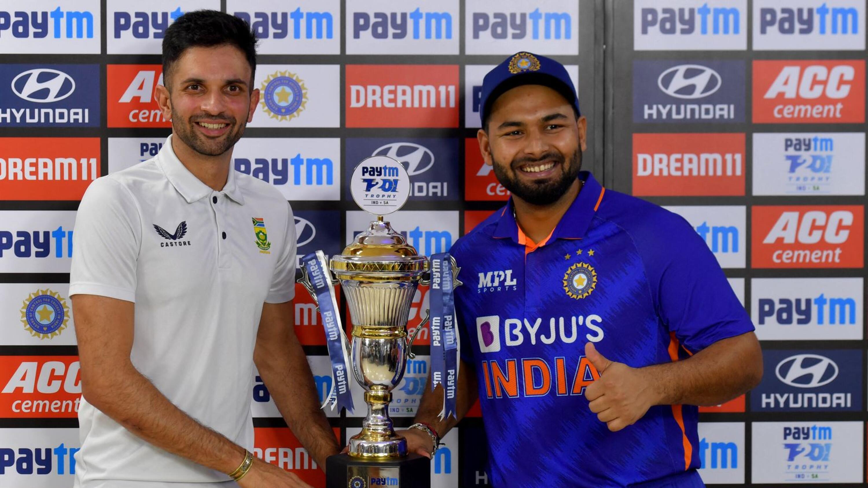 South Africa's Keshav Maharaj (L) and India's Rishabh Pant pose for pictures as they share the trophy after rains interrupted the fifth and Twenty20 international cricket match at the at the M. Chinnaswamy Stadium in Bangalore on Sunday