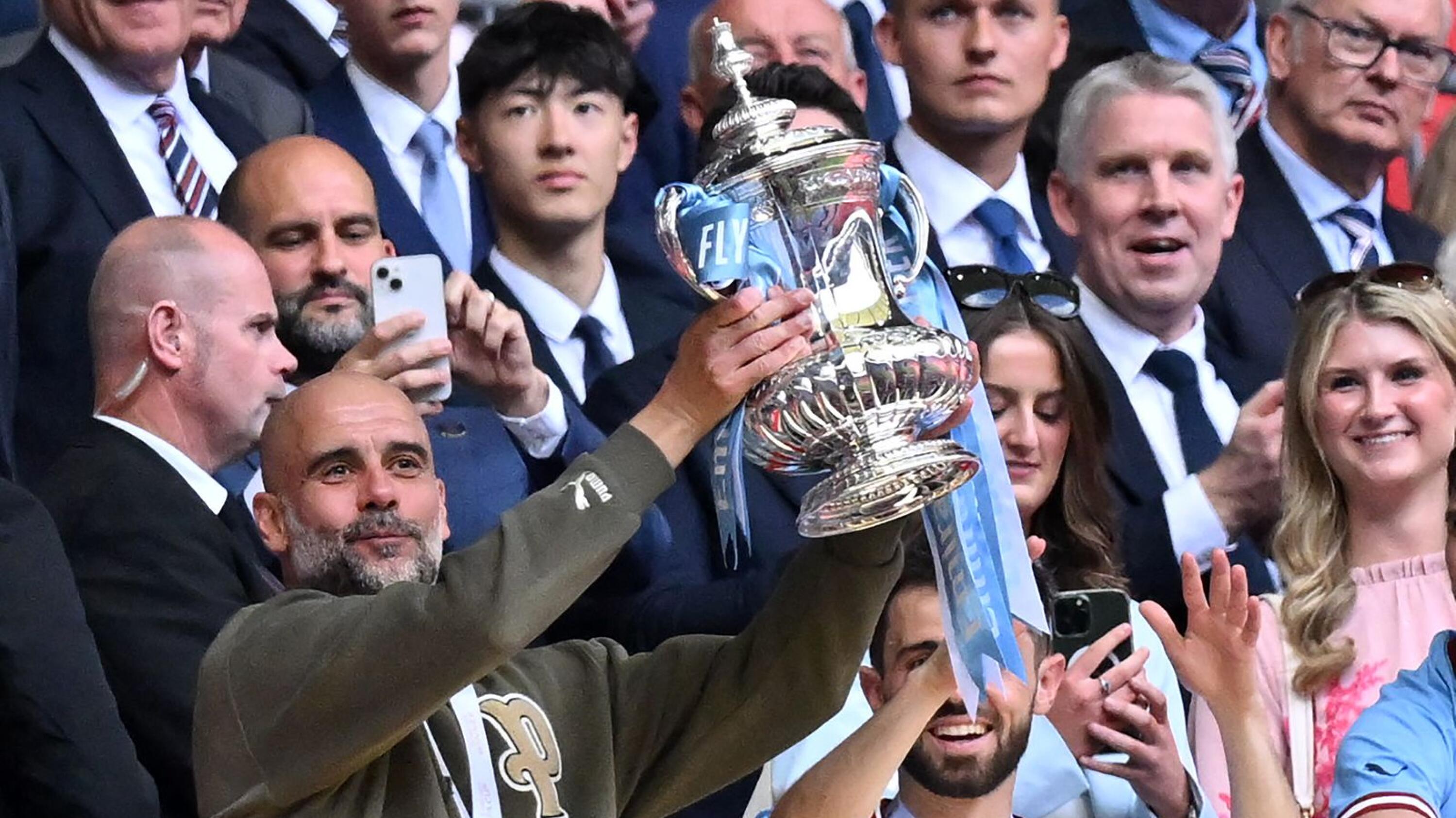 Manchester City manager Pep Guardiola holds up the trophy after they beat Manchester United in Saturday’s FA Cup final at Wembley Stadium