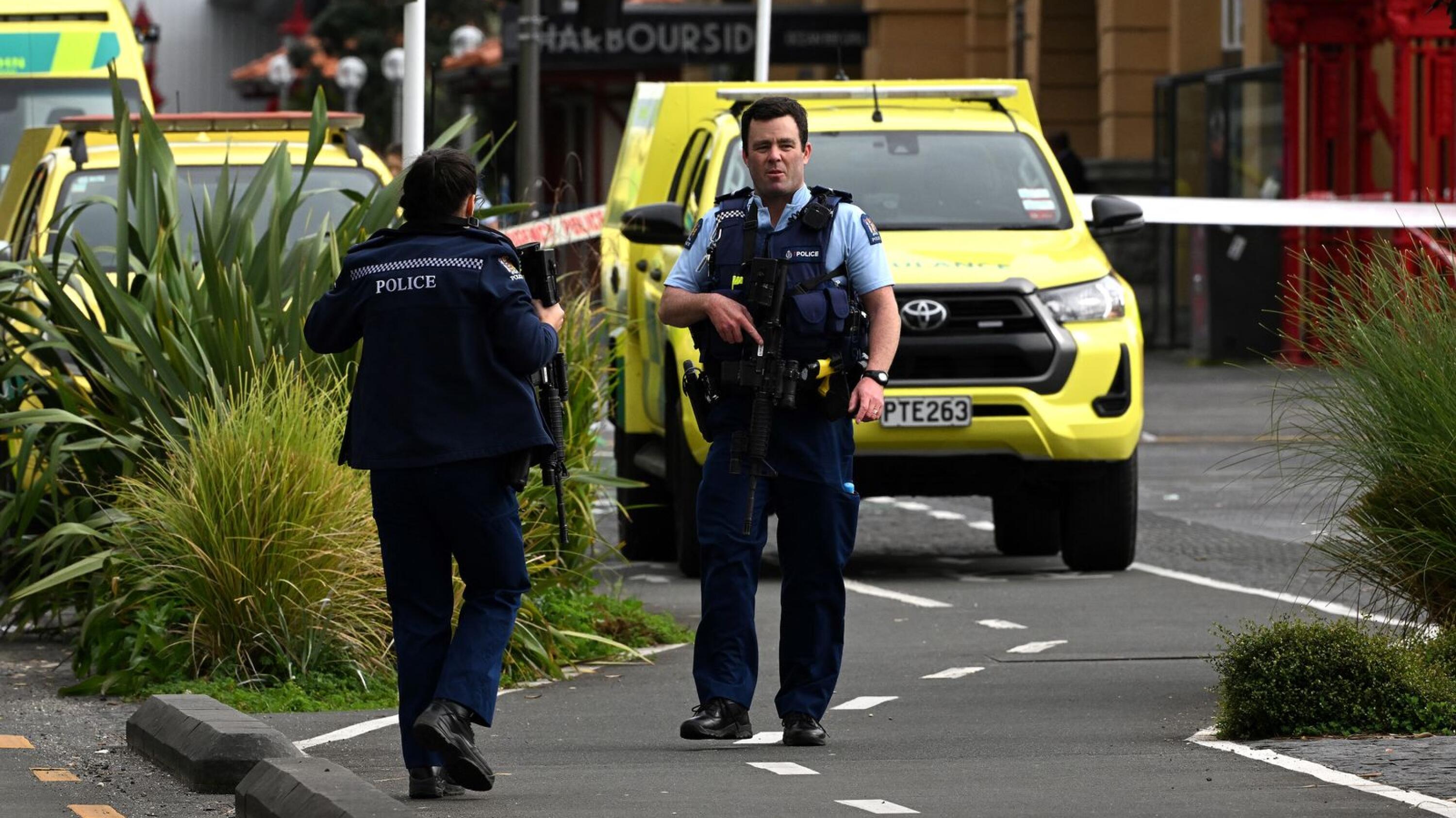 Police officers cordon off an area near the site of a shooting in central Auckland