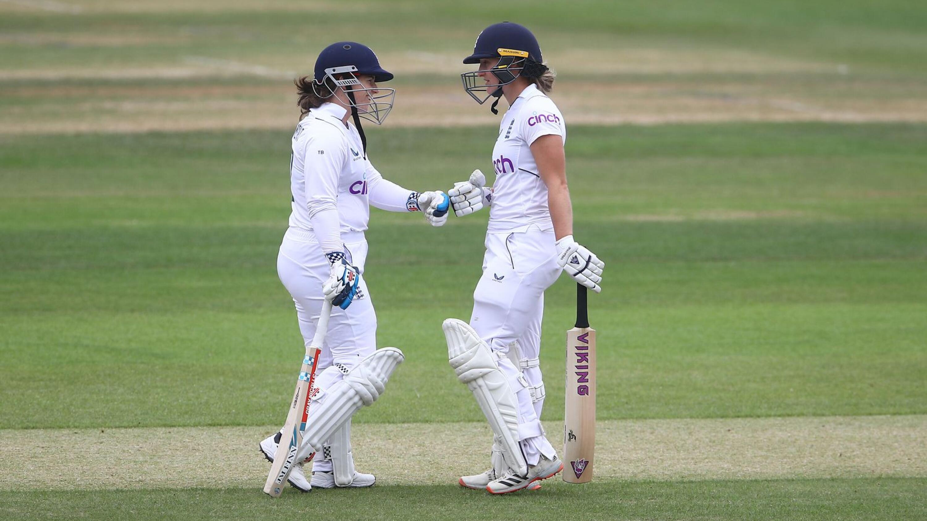 Tammy Beaumont and Emma Lamb of England bump fists during play on day two of their Test match against South Africa at Cooper Associates County Ground, Taunton, on Tuesday
