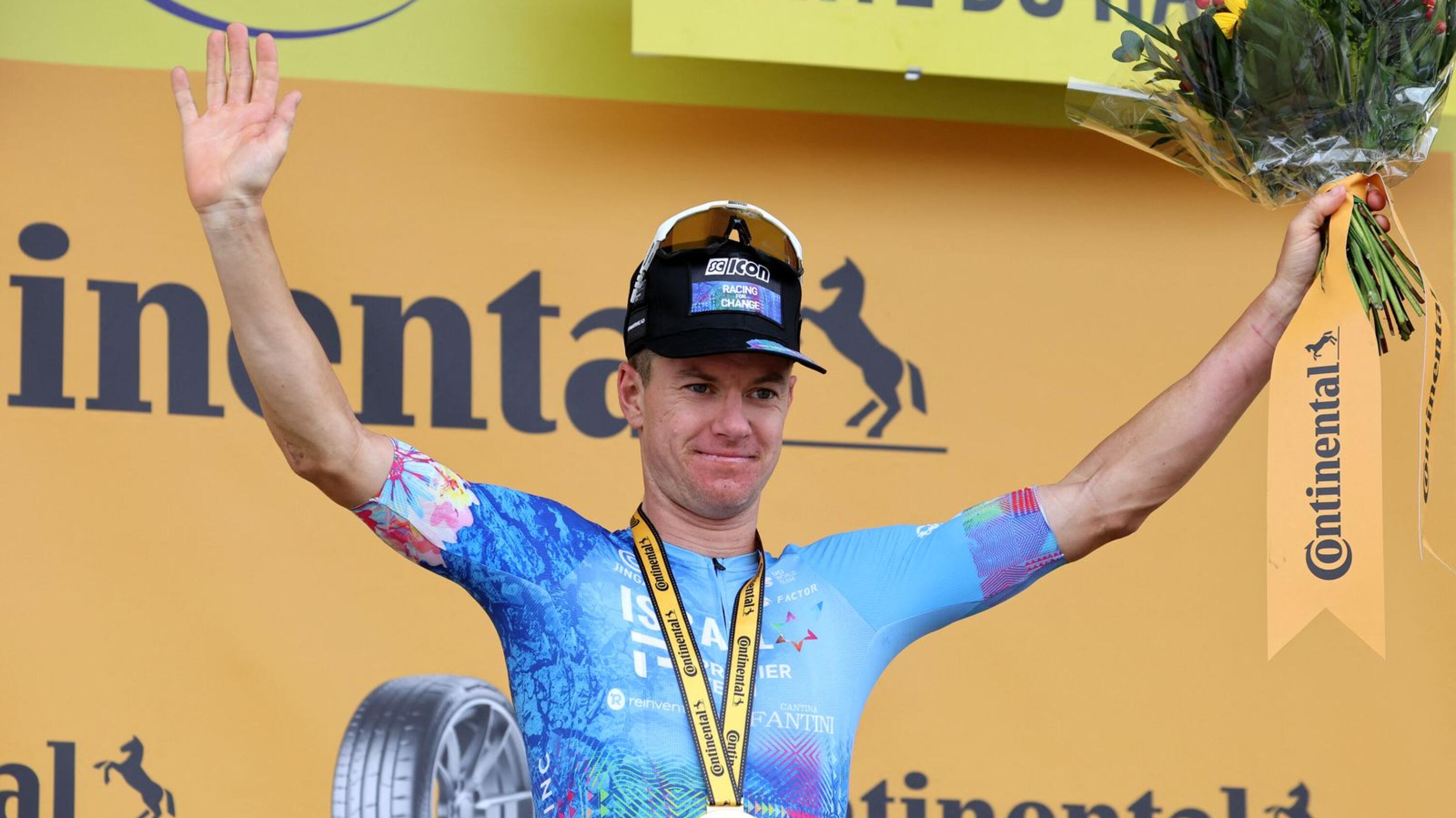 Israel-Premier Tech team's Australian rider Simon Clarke celebrates on the podium after winning the 5th stage of the 109th edition of the Tour de France cycling race, 153,7 km between Lille and Arenberg Porte du Hainaut, in northern France, on Wednesday