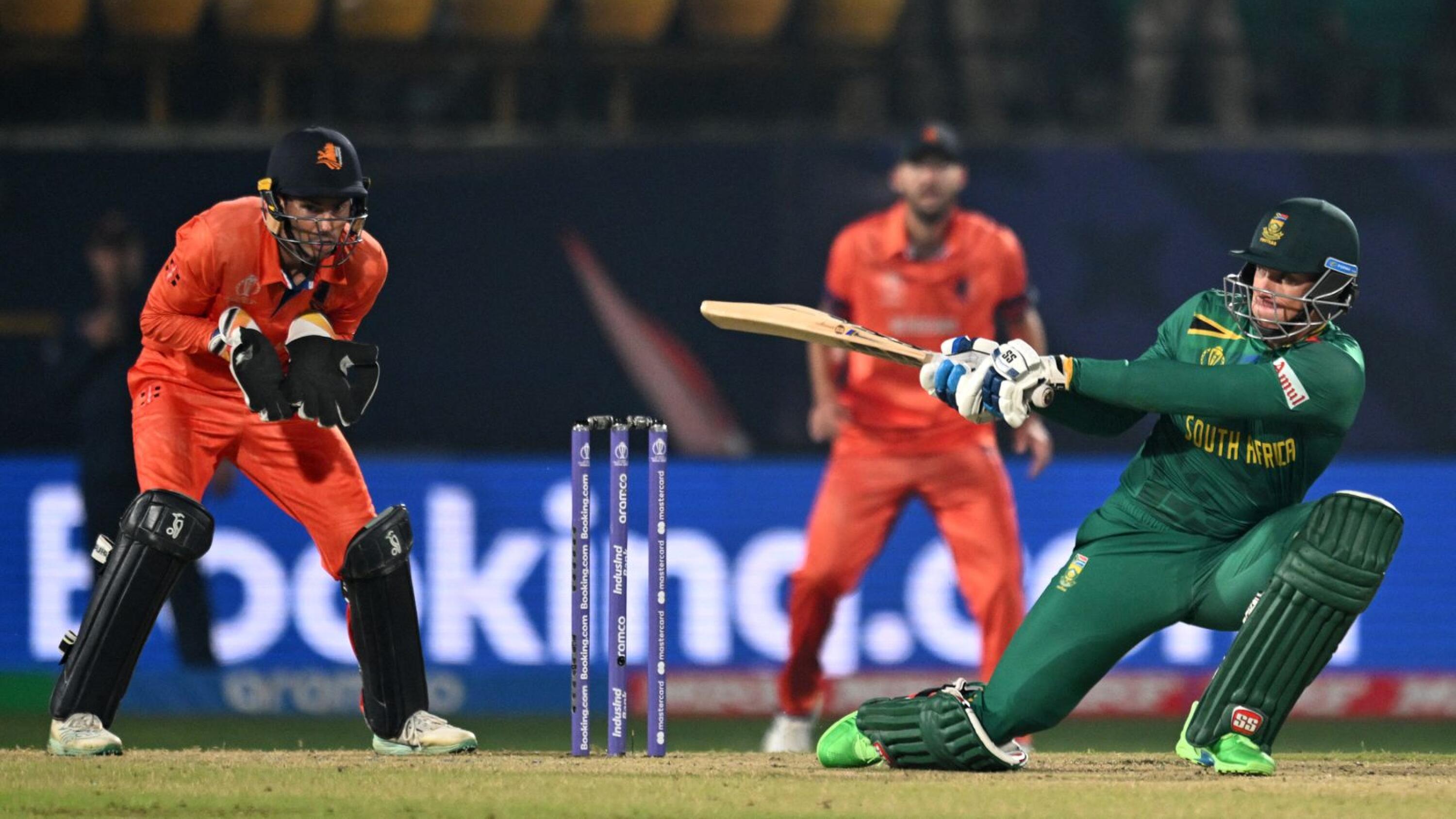 South Africa's Rassie van der Dussen (R) plays a shot as Netherlands' wicketkeeper captain Scott Edwards watches during the 2023 ICC Men's Cricket World Cup one-day international (ODI) match between South Africa and Netherlands at the Himachal Pradesh Cricket Association Stadium in Dharamsala