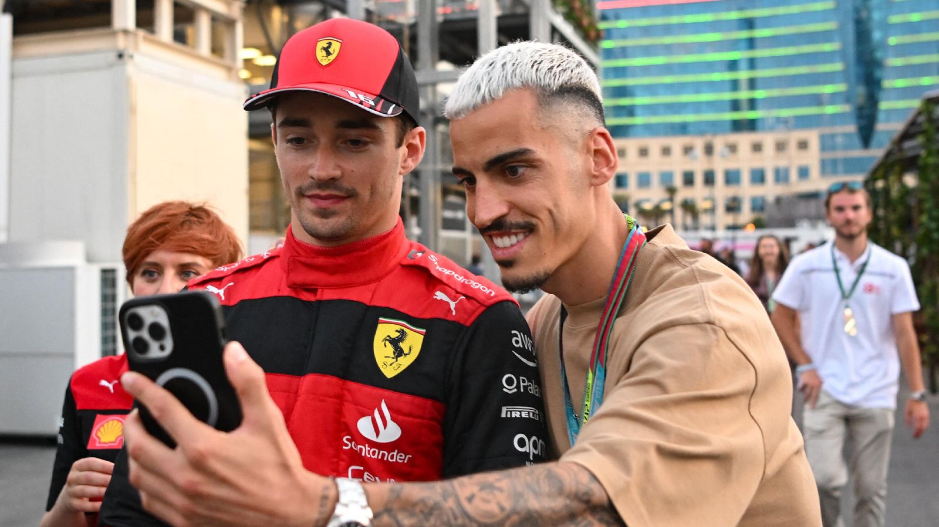 Pole position winner Ferrari's Monegasque driver Charles Leclerc poses for pictures with fans after the qualifying session for the Formula One Azerbaijan Grand Prix at the Baku City Circuit in Baku on Saturday