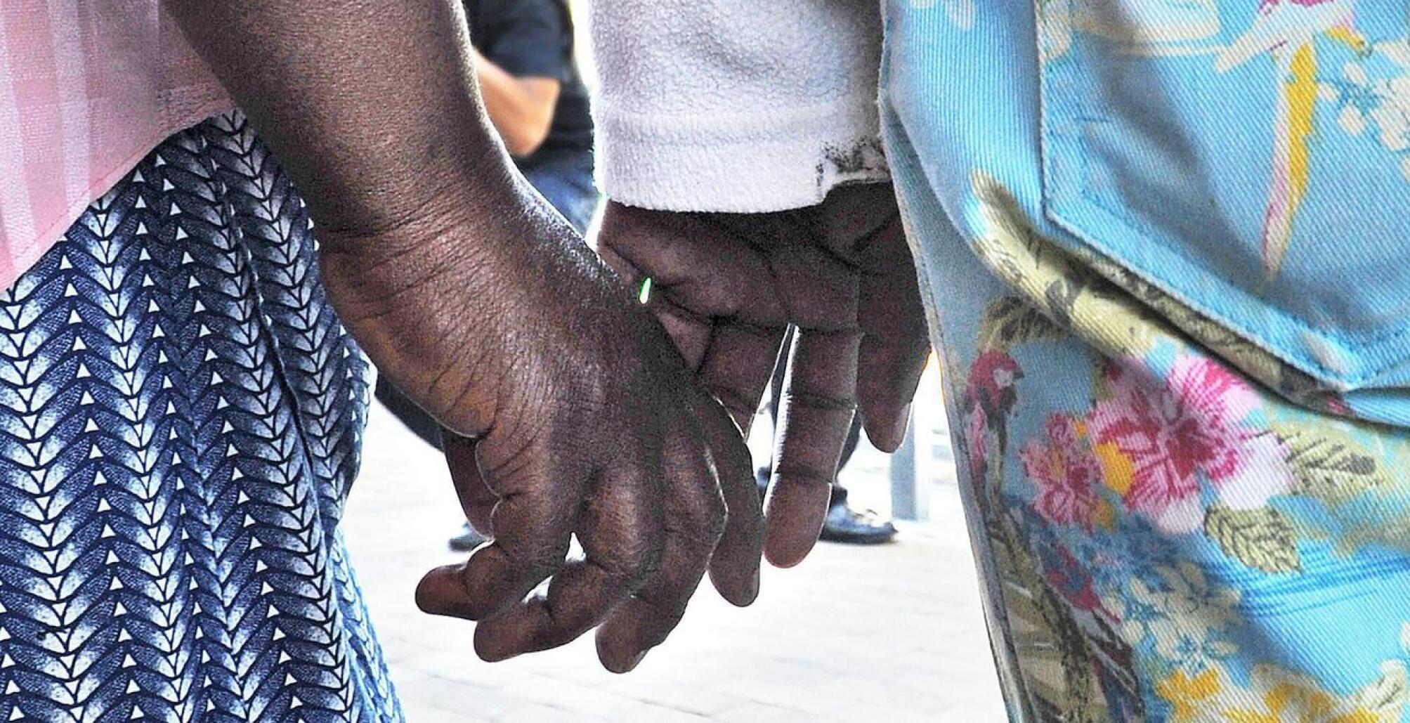 Hands of two women holding hands 