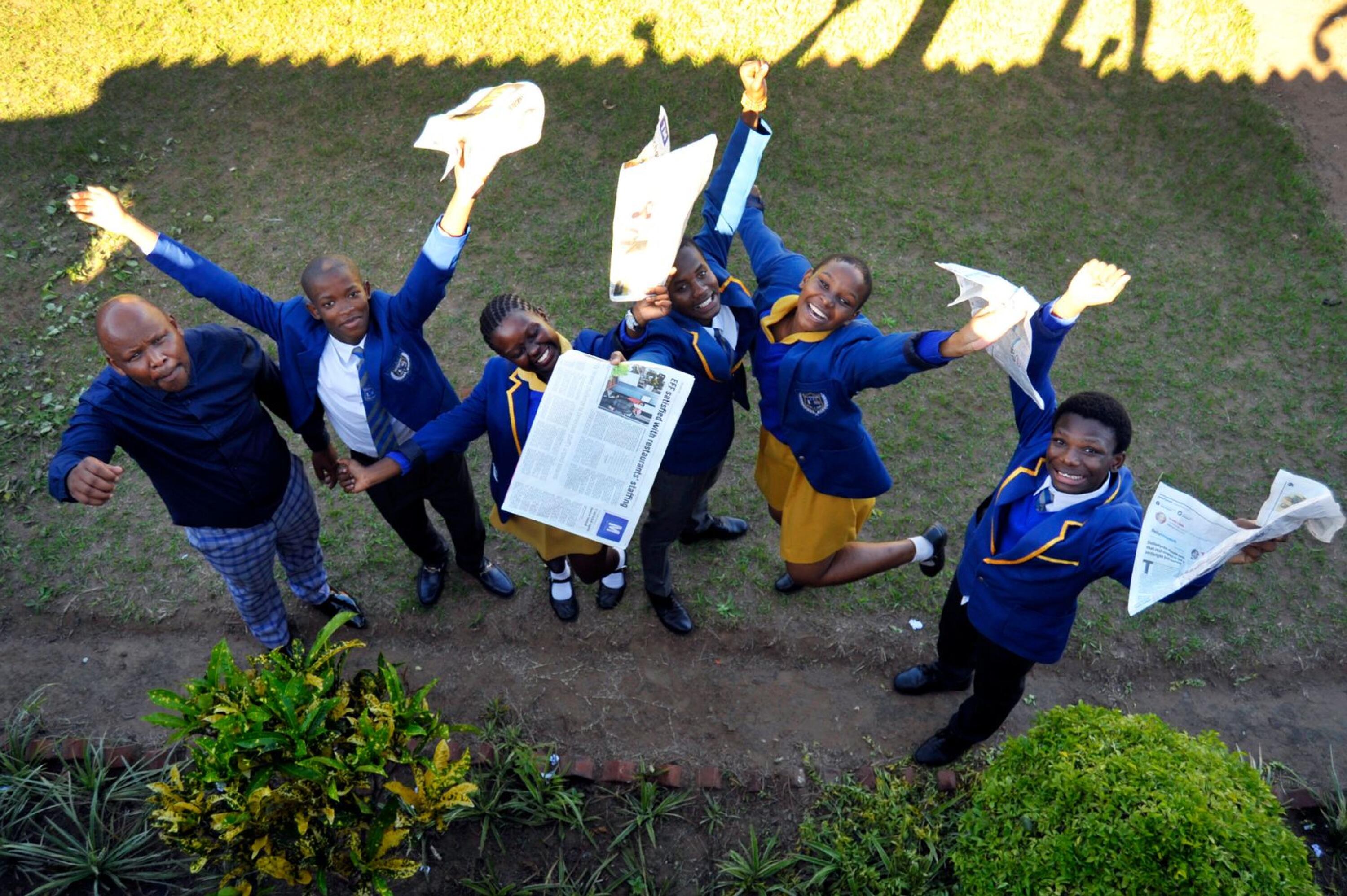A group of learners with newspapers