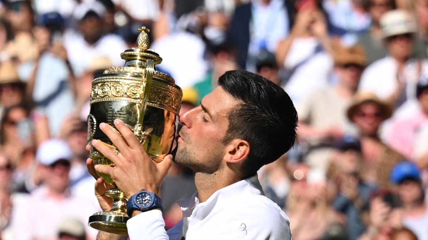 Serbia's Novak Djokovic kisses his trophy after defeating Australia's Nick Kyrgios during the men's singles final tennis match on the fourteenth day of the 2022 Wimbledon Championships at The All England Tennis Club in Wimbledon, southwest London, on Sunday