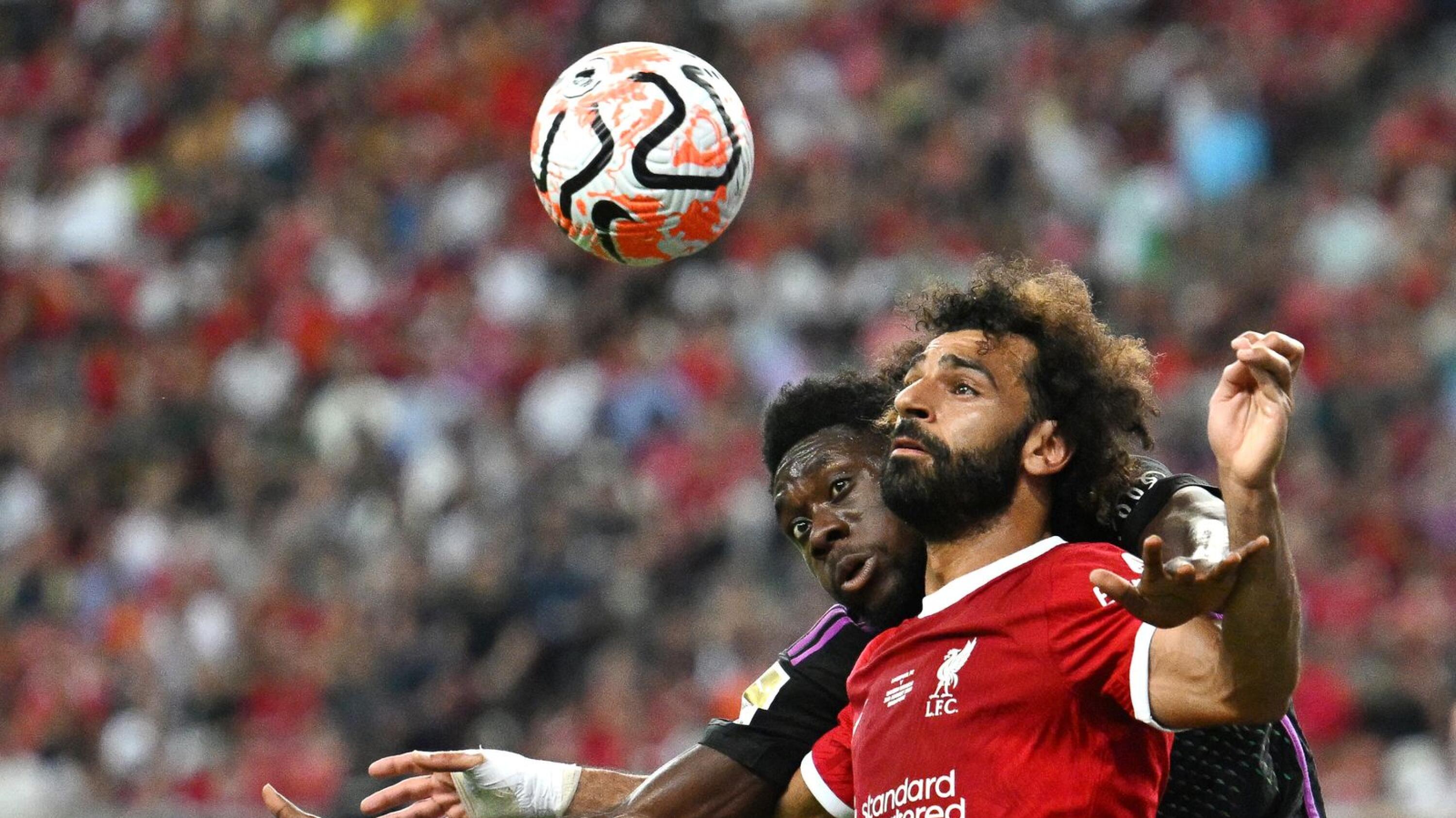 Liverpool's Egyptian striker Mohamed Salah (front) fights for the ball against Bayern Munich's Canadian midfielder Alphonso Davies during the Singapore Festival of Football pre-season friendly match in Singapore
