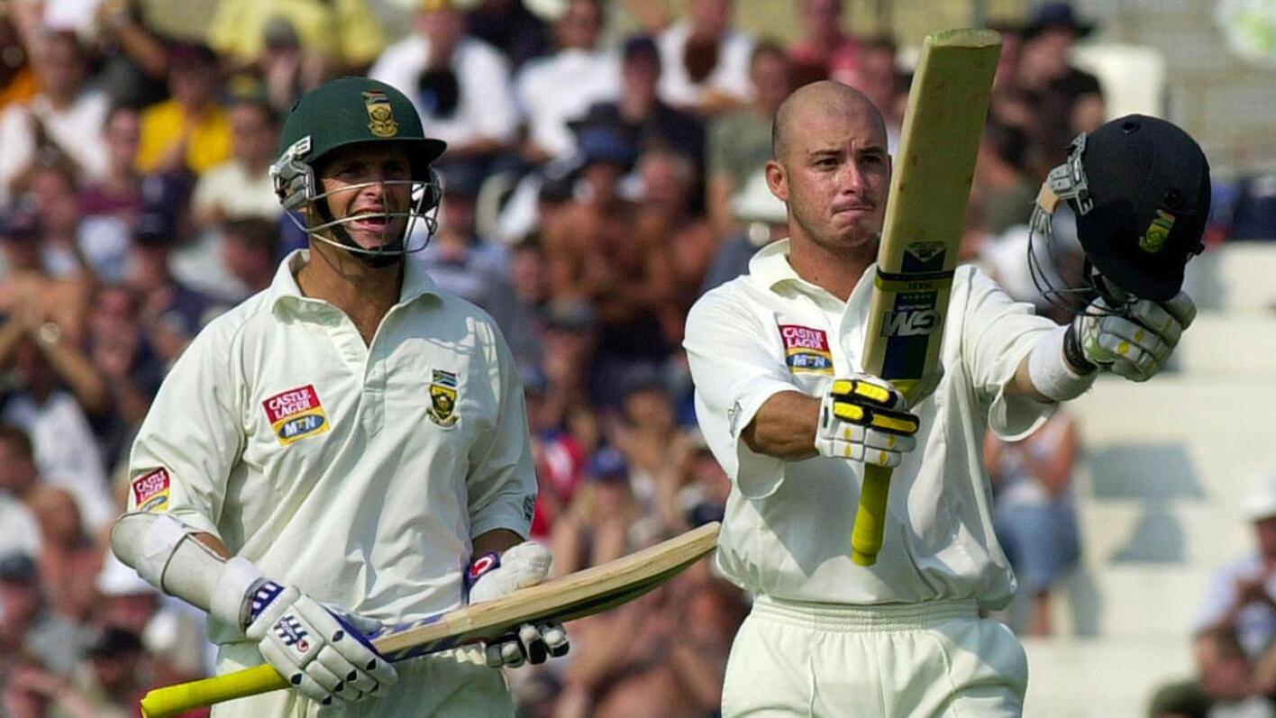 South Africa's Herschelle Gibbs (right) is watched by teammate Gary Kirsten as he celebrates reaching his century against England during fifth and final Test cricket match at the Oval Cricket Ground in London on September 4, 2003