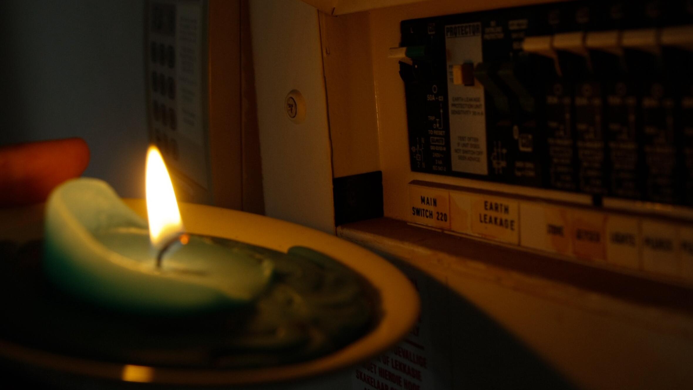 A candle is seen near a electrical distribution board