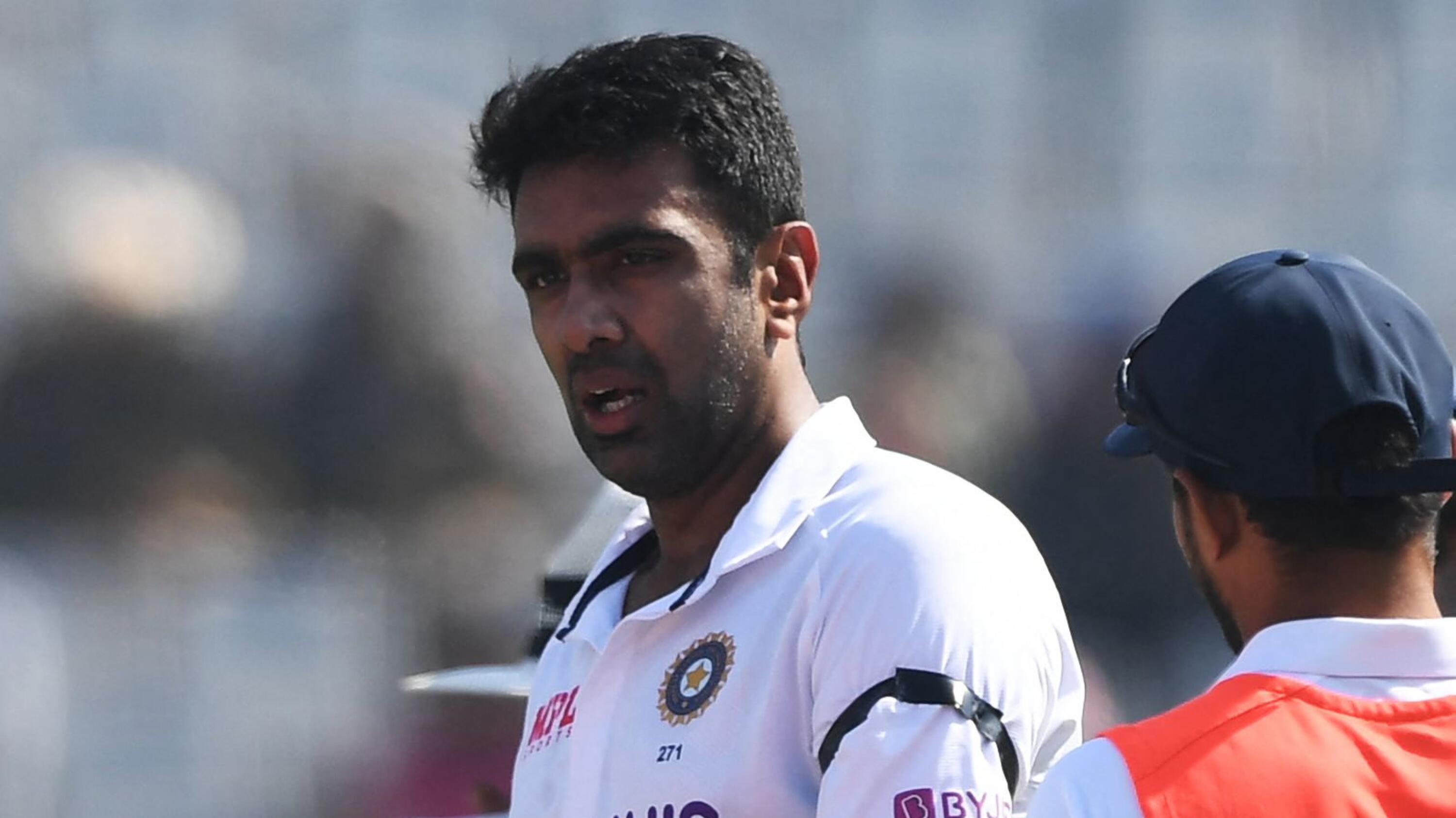 India's Ravichandran Ashwin looks on while wearing a black band to commemorate late former Australian cricketers Shane Warne and Rodney Marsh during a break of the second day of the first Test cricket match between India and Sri Lanka at the Punjab Cricket Association Stadium in Mohali on Saturday