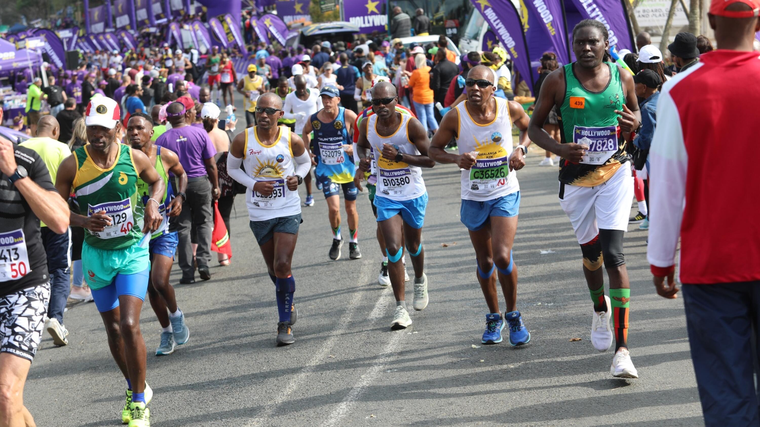 A large group of people running on a road during a marathon.