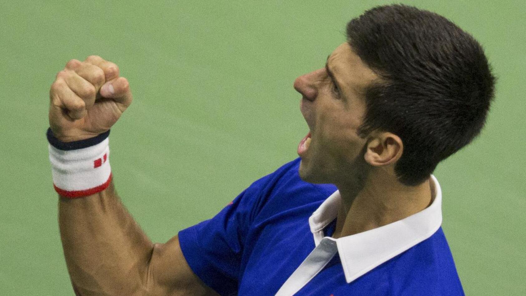 Novak Djokovic of Serbia celebrates winning a point against Roger Federer of Switzerland in the third set during their men's singles final match at the US Open in New York, in 2015