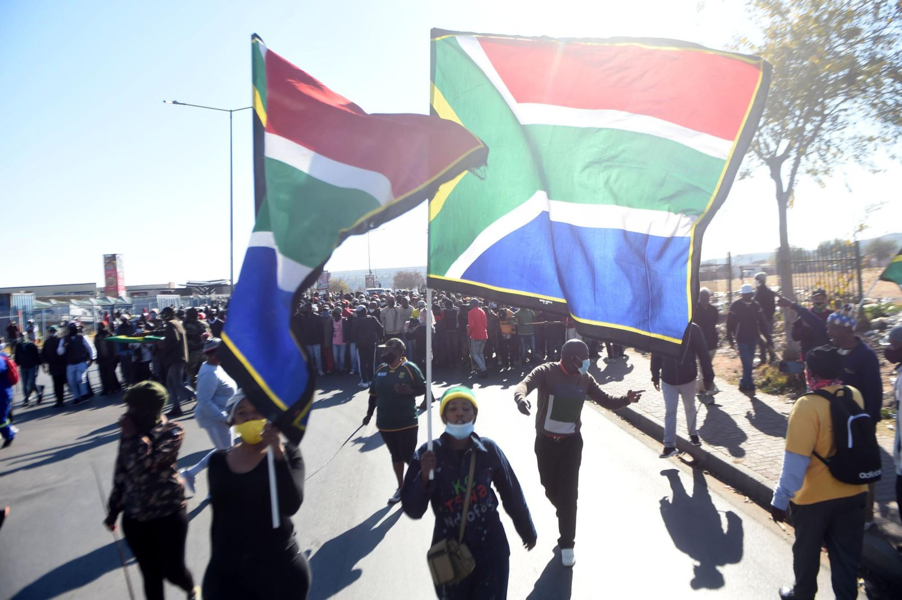 Crowds of people holding South African flag