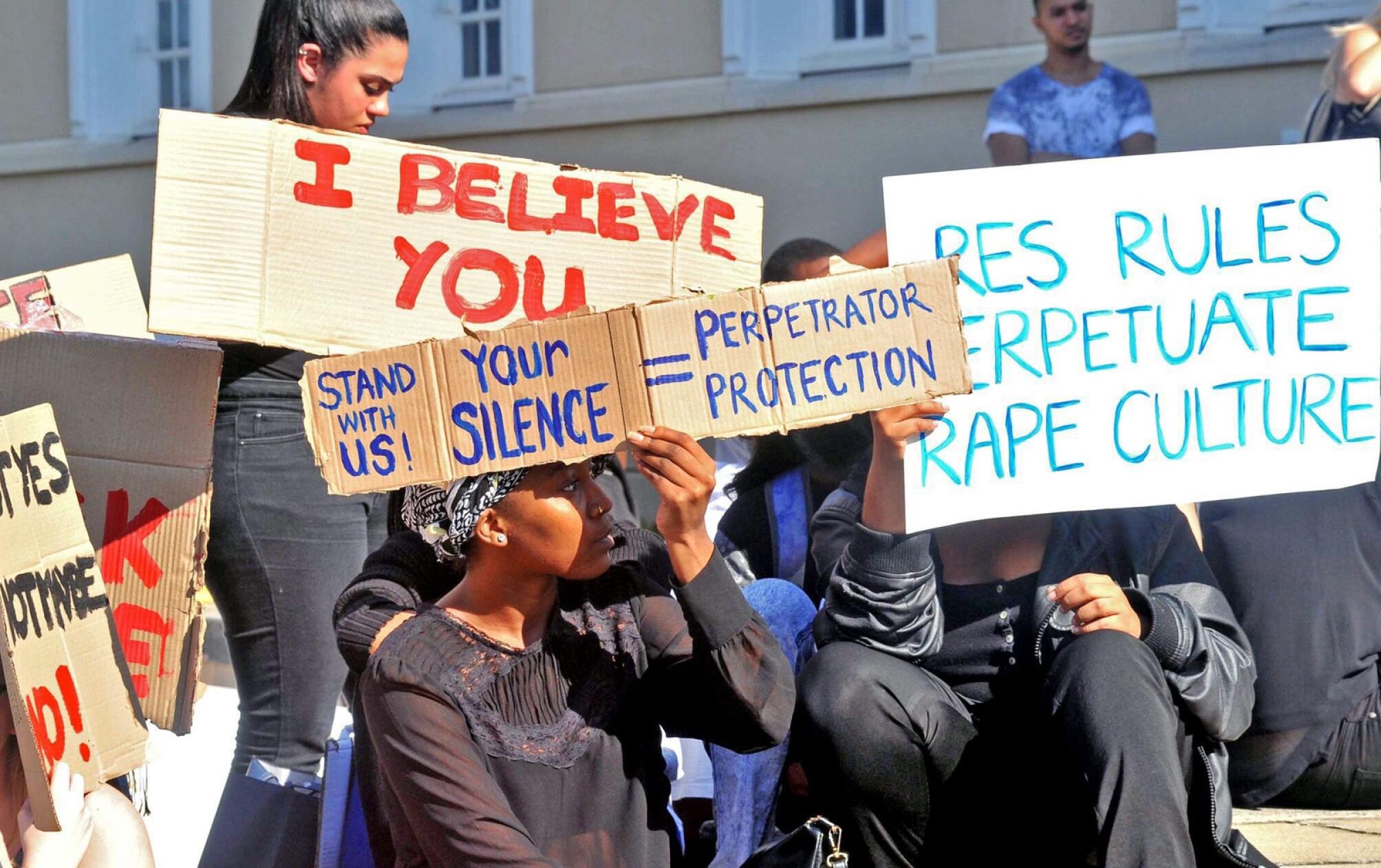 A group of activists waving placards denouncing rape 